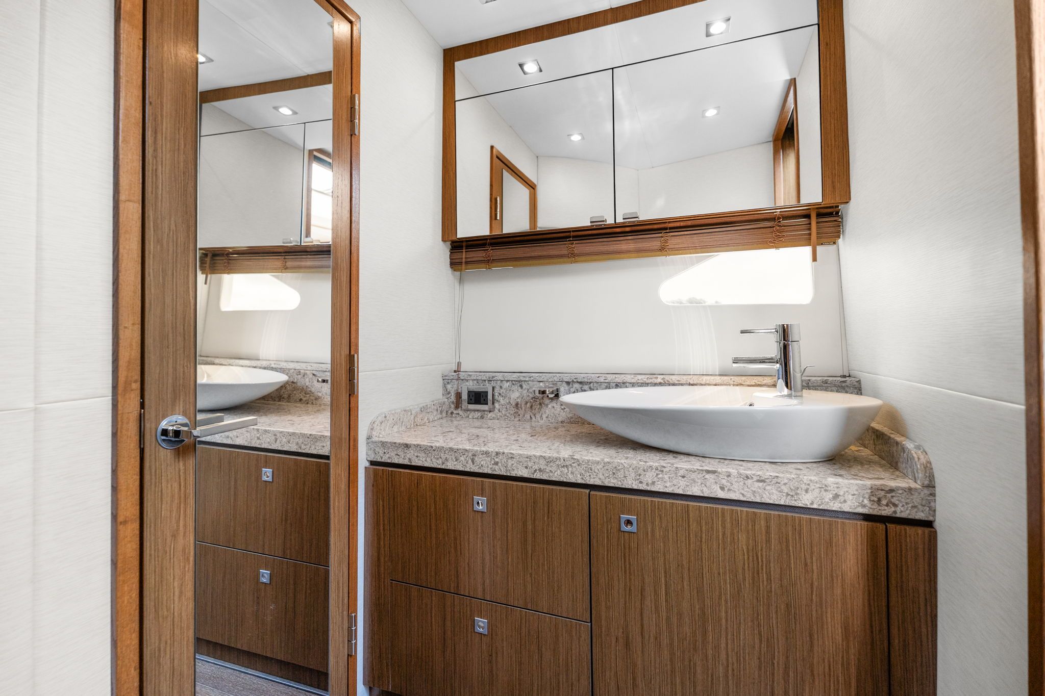 The image shows an elegant bathroom with a modern sink and wooden cabinets.