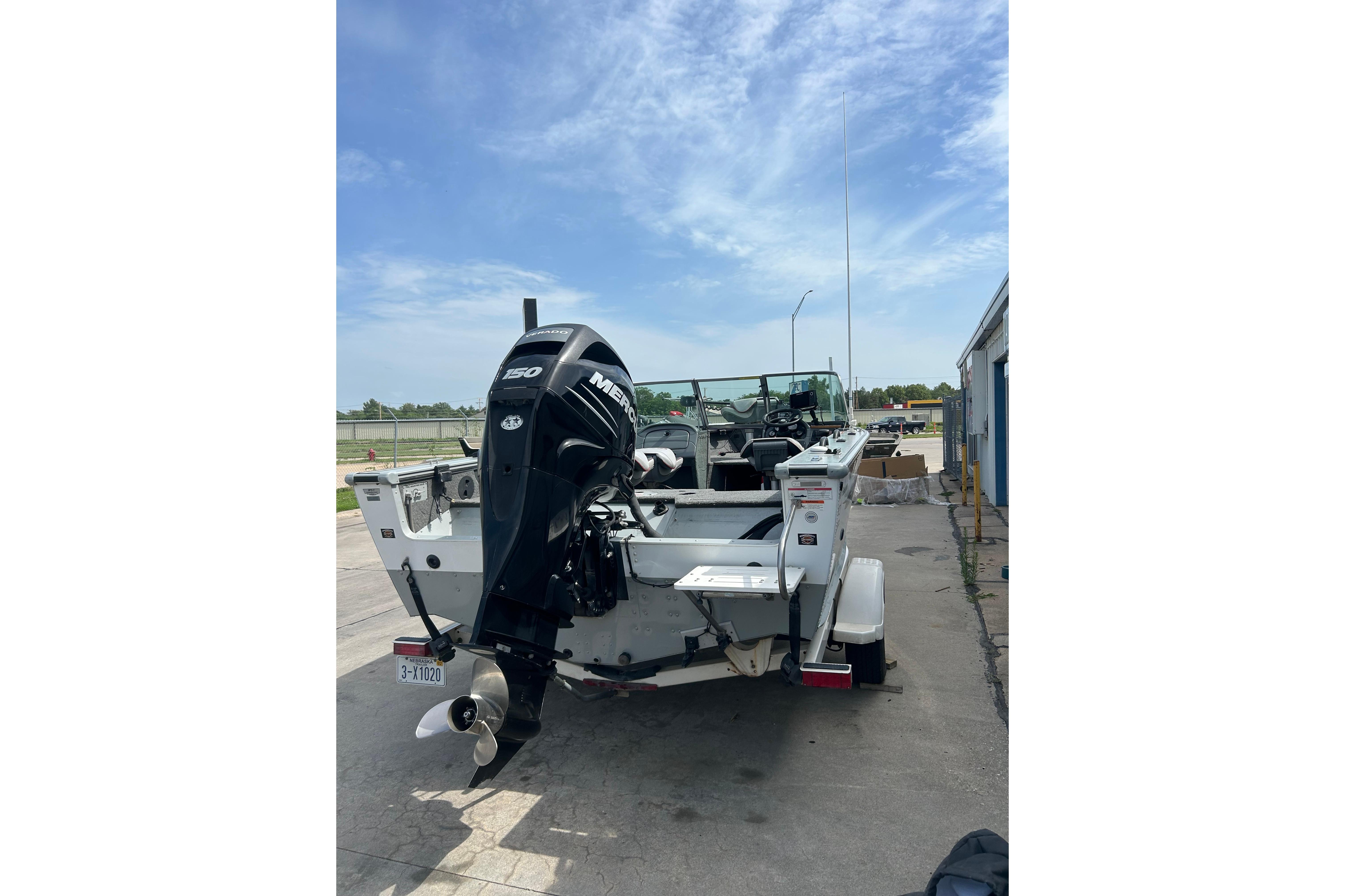 2008 Lund 1850 Fisherman boat with Mercury 150 engine, parked outdoors.