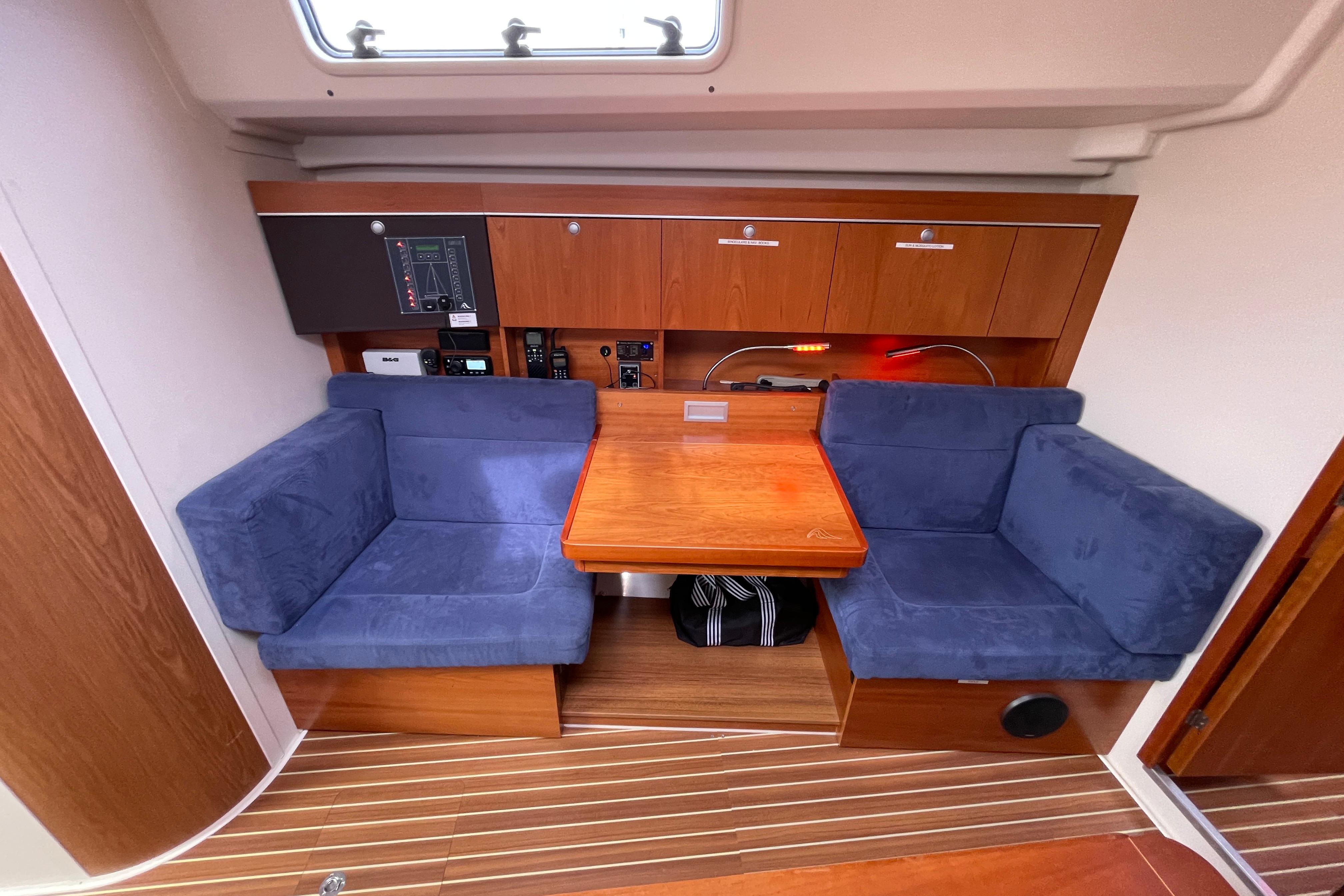 Interior of 2014 Hanse 415 yacht with blue seating and wooden table.