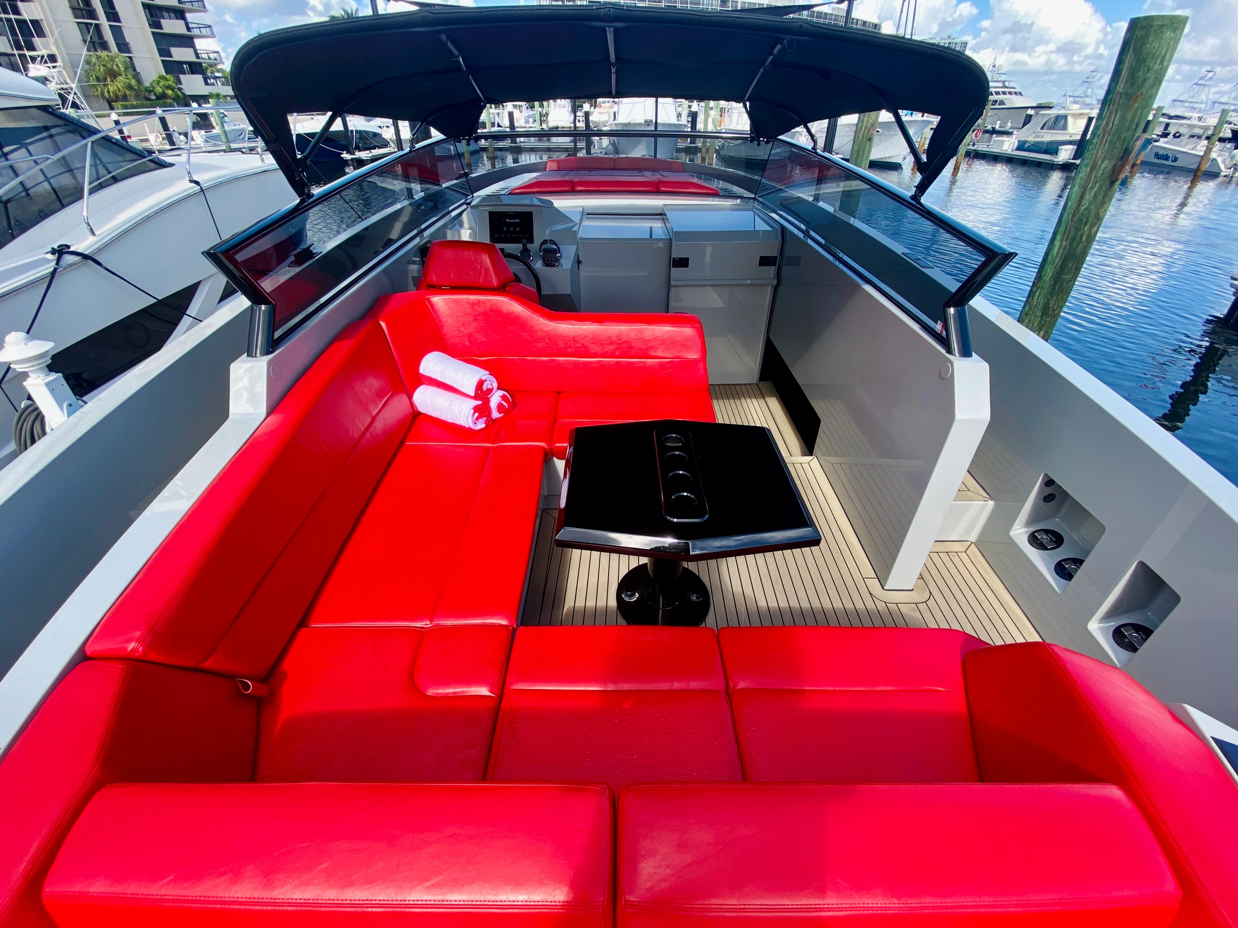Luxurious 2020 Vanquish VQ45 yacht with vibrant red seating and sleek design at marina.