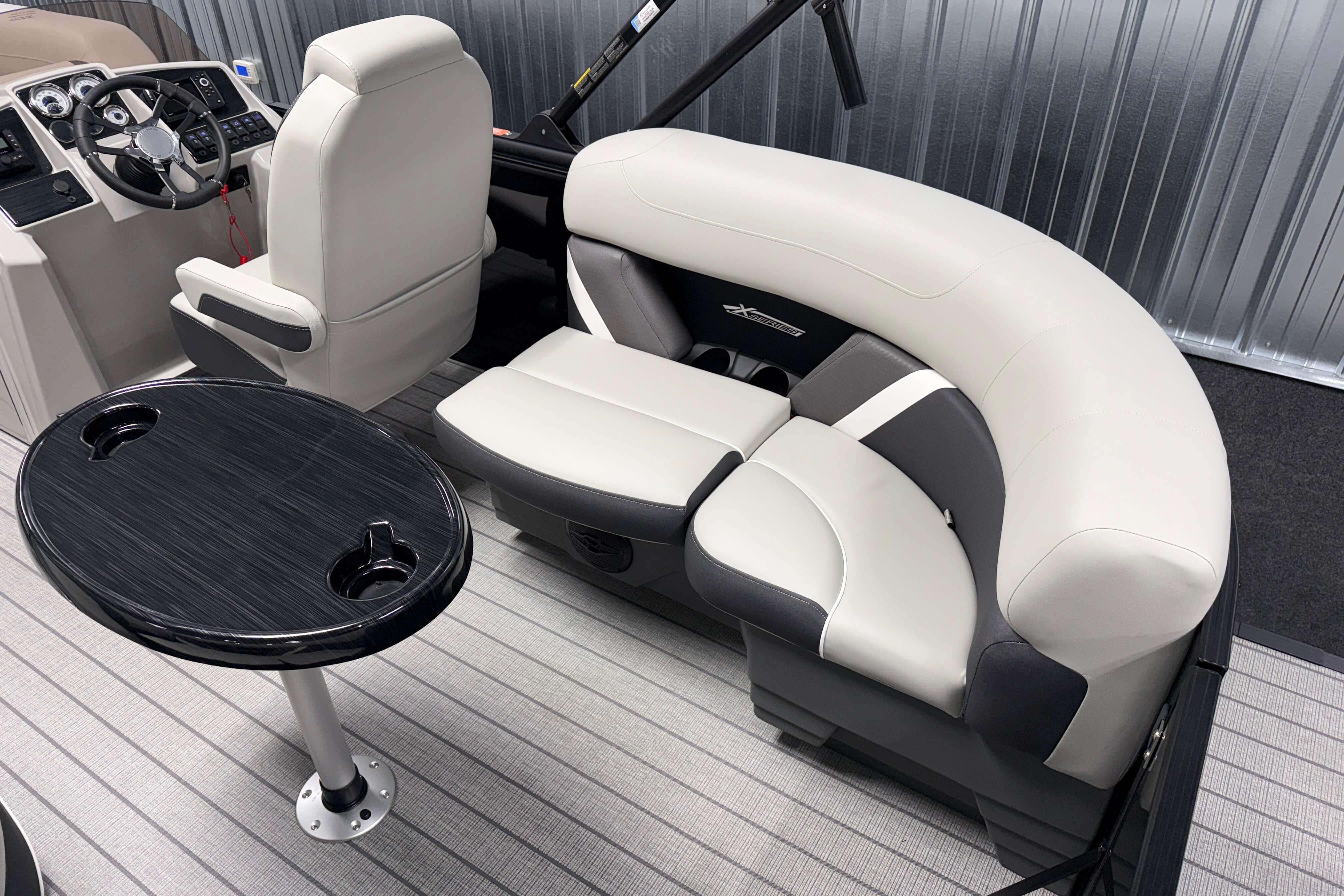 2026 Sylvan Mirage X1 boat interior with plush seating and sleek black table.