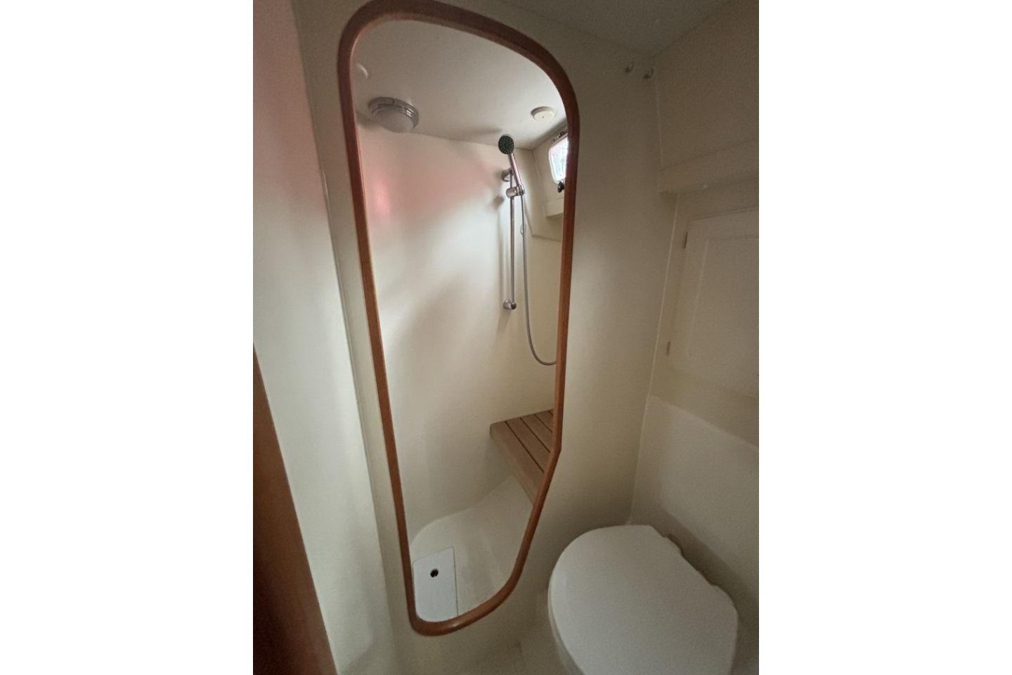 Compact bathroom in a 2004 Regina 43 yacht, featuring a shower and toilet.