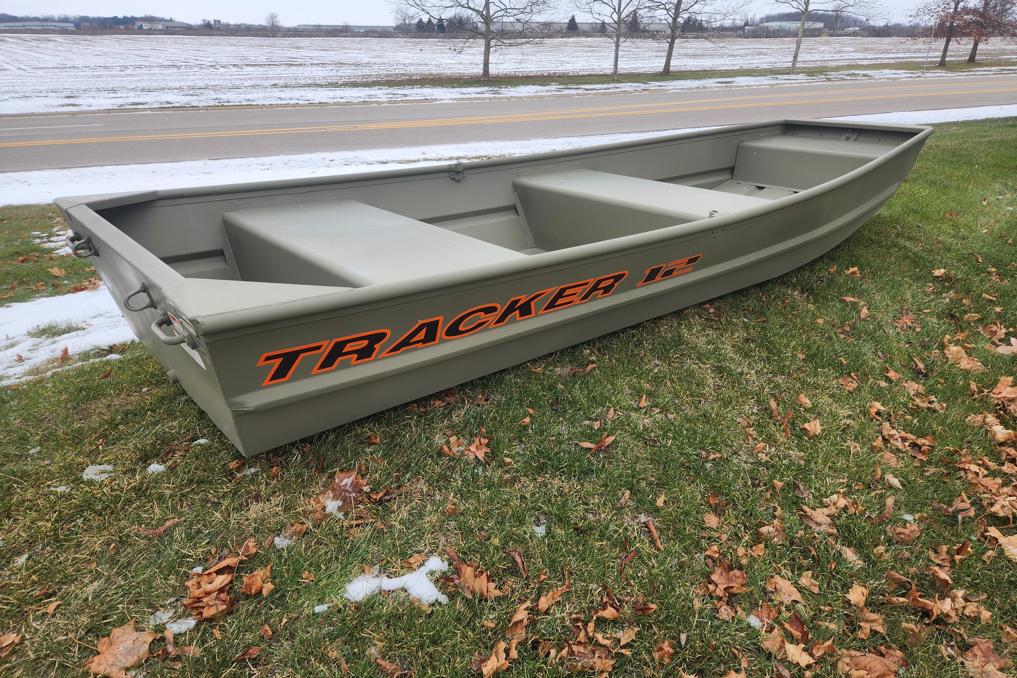 2026 Tracker Grizzly 12 Jon boat on grass, near a snowy roadside.
