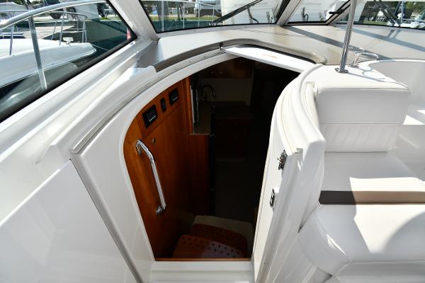 2010 Cruisers Yachts 390 Sports Coupe interior entrance with sleek white seating and wooden accents.