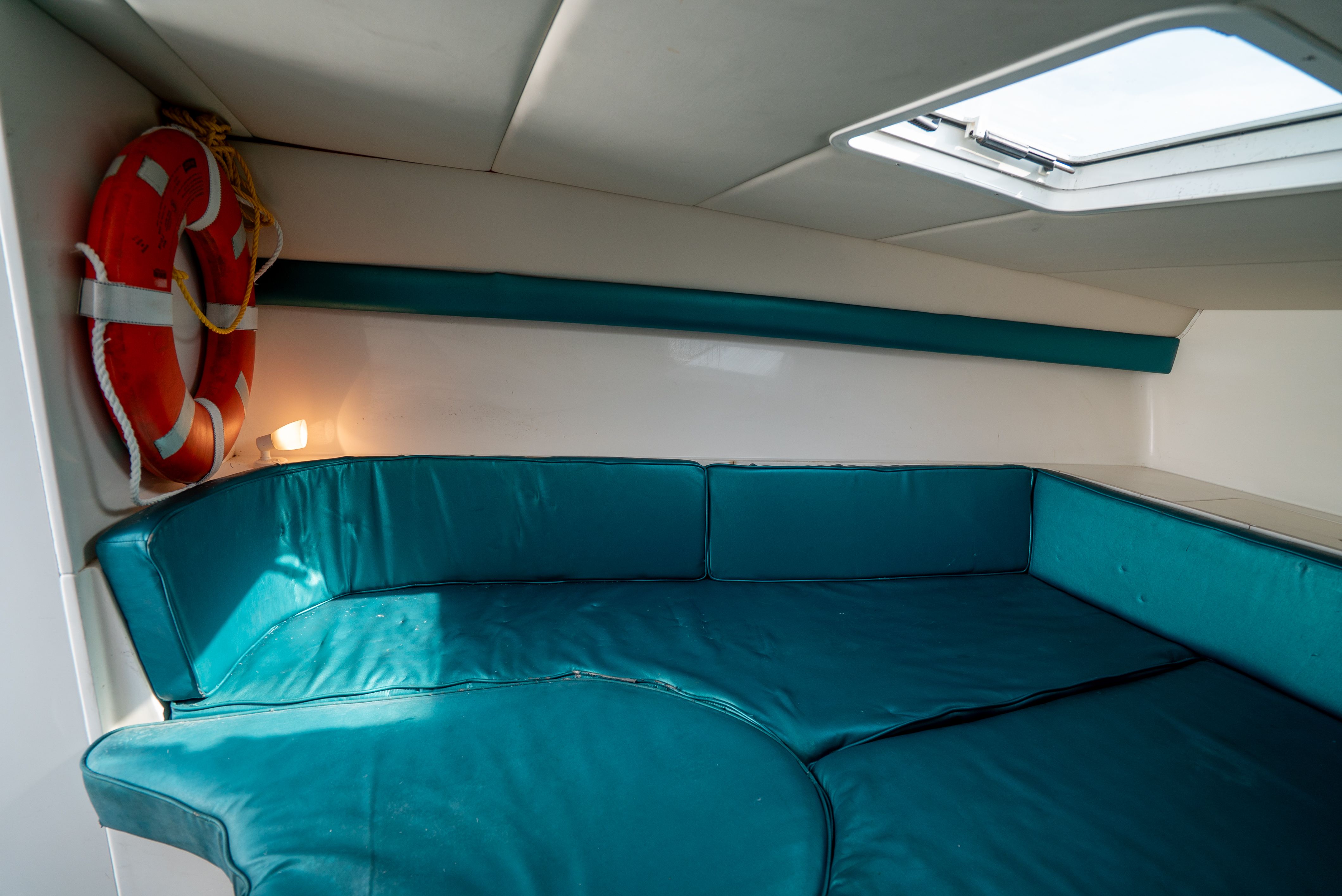 Interior of a 2006 Tempest Offshore 40 with blue cushions and a life preserver.