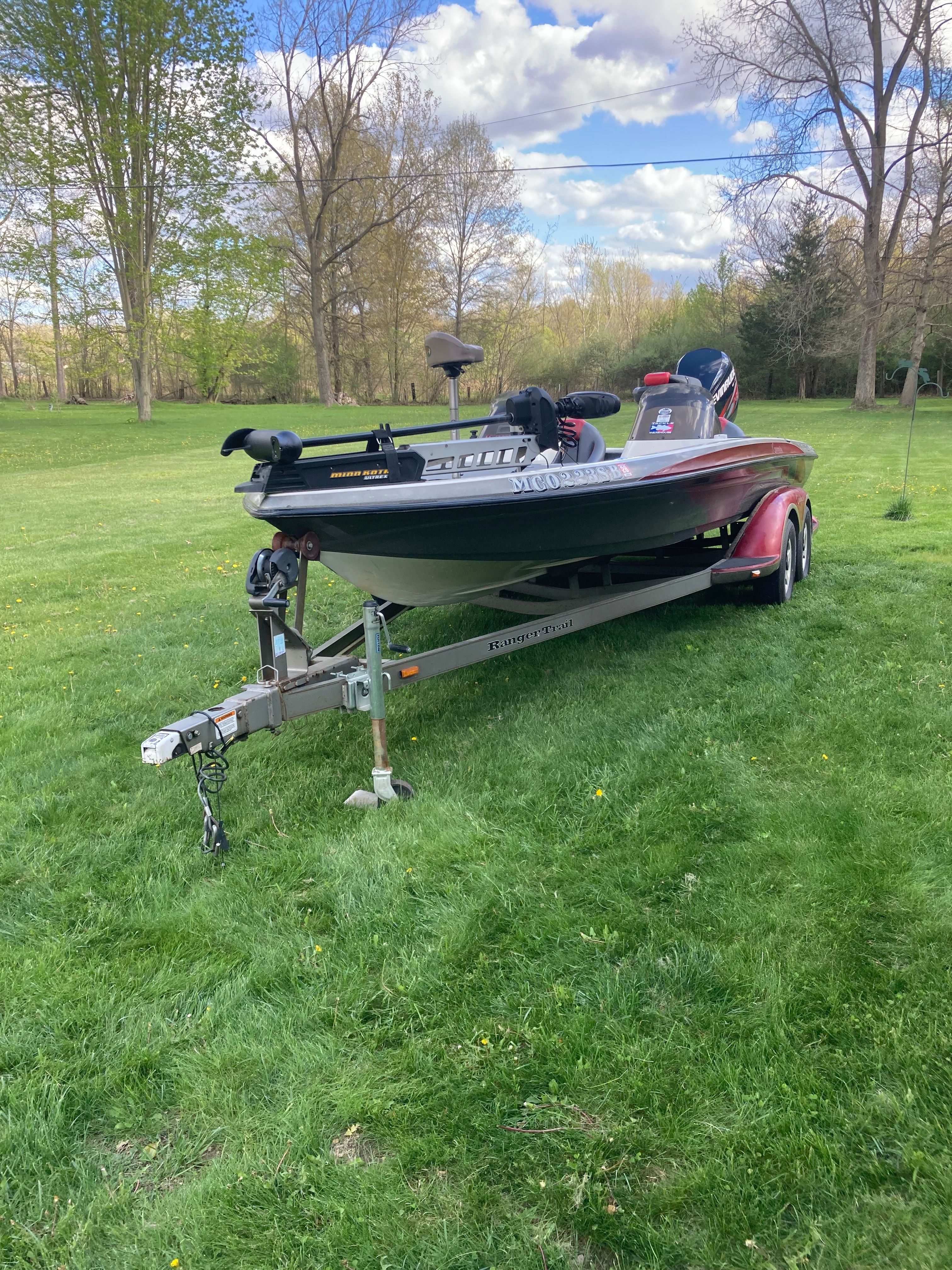 A 2002 Ranger 522DVX Comanche on a trailer, set on a grassy field.