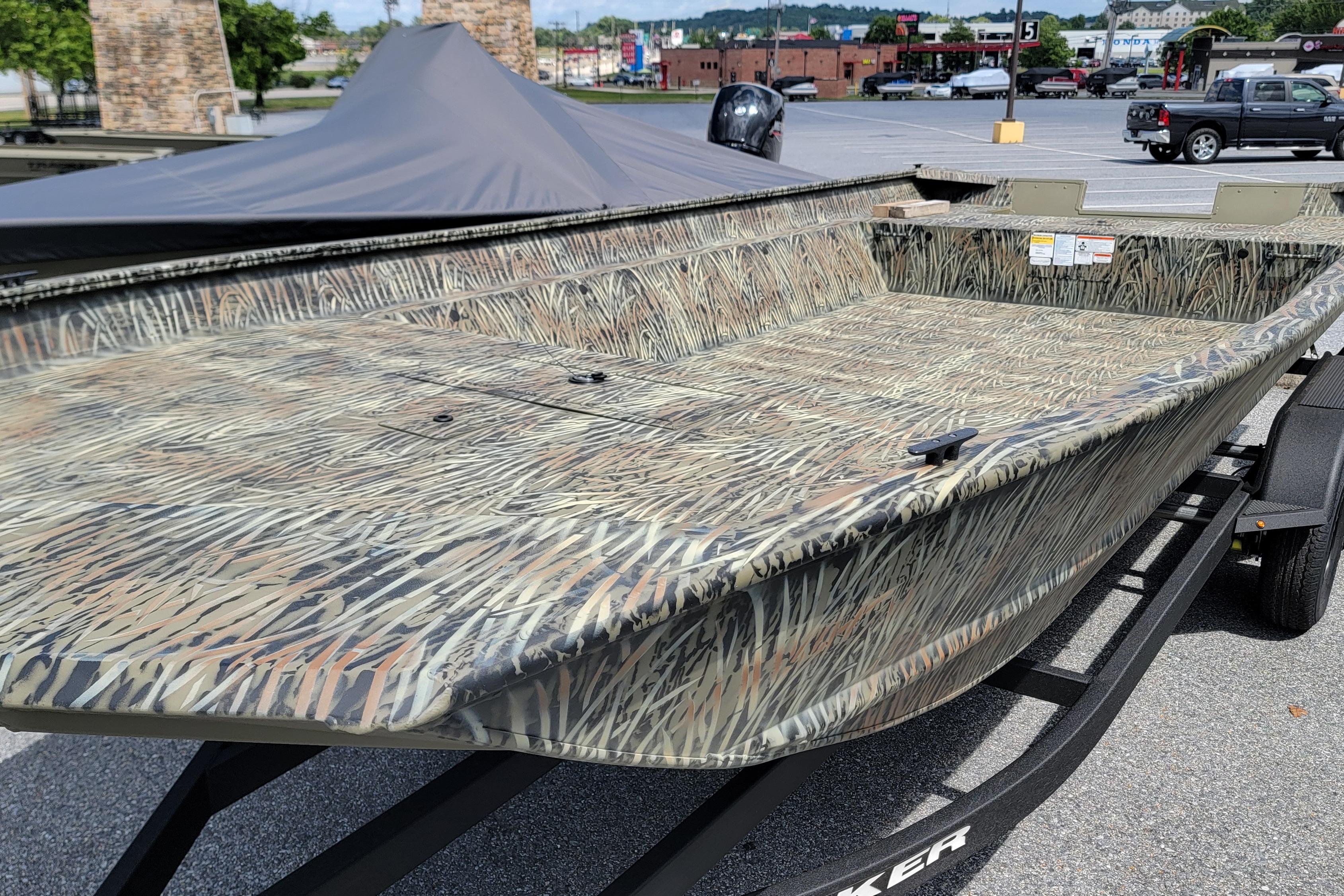 2026 Tracker Grizzly 2072 Utility boat with camouflage design on a trailer in a parking lot.