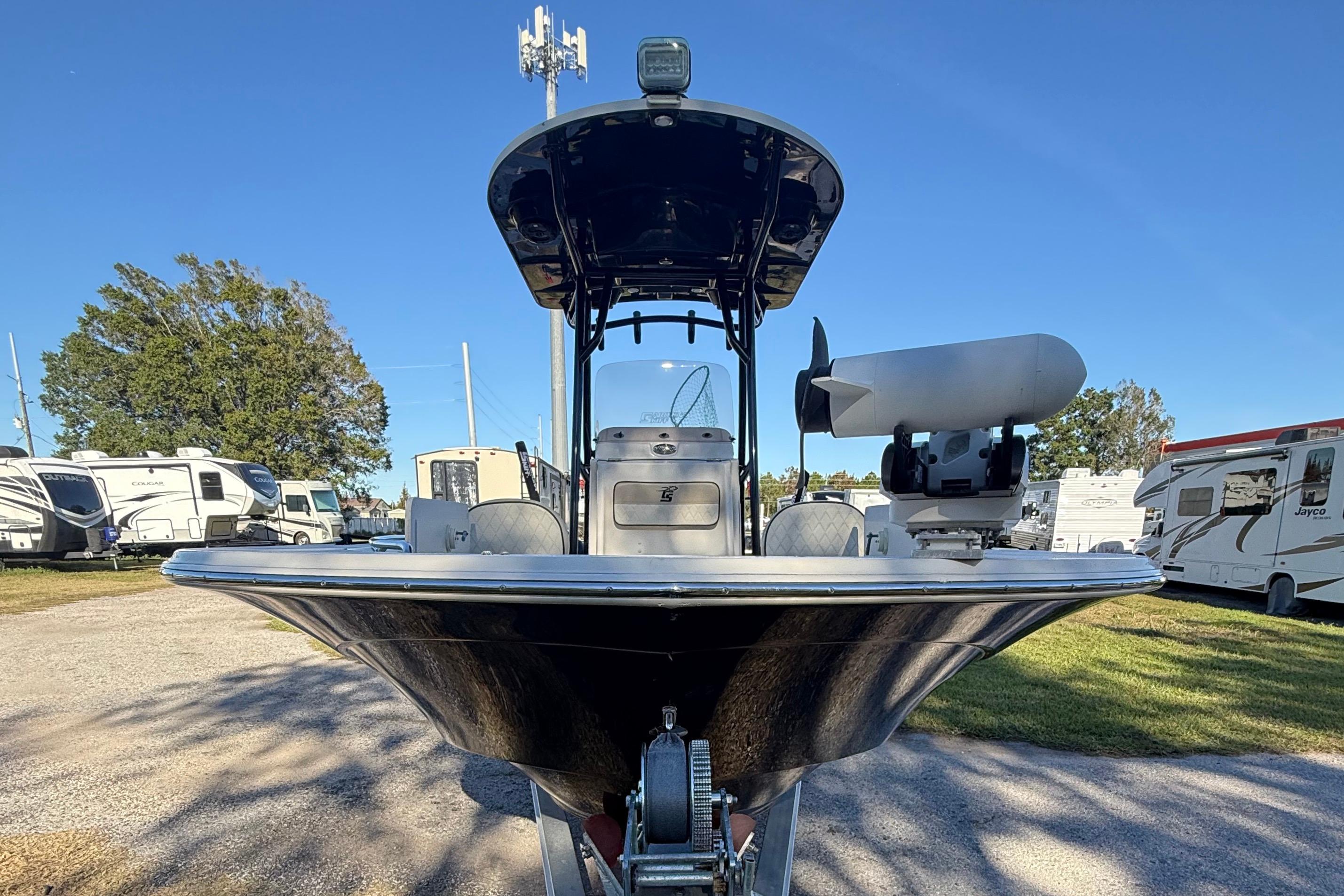 2021 Carolina Skiff 26 Ultra Elite boat on trailer, surrounded by RVs and trees.