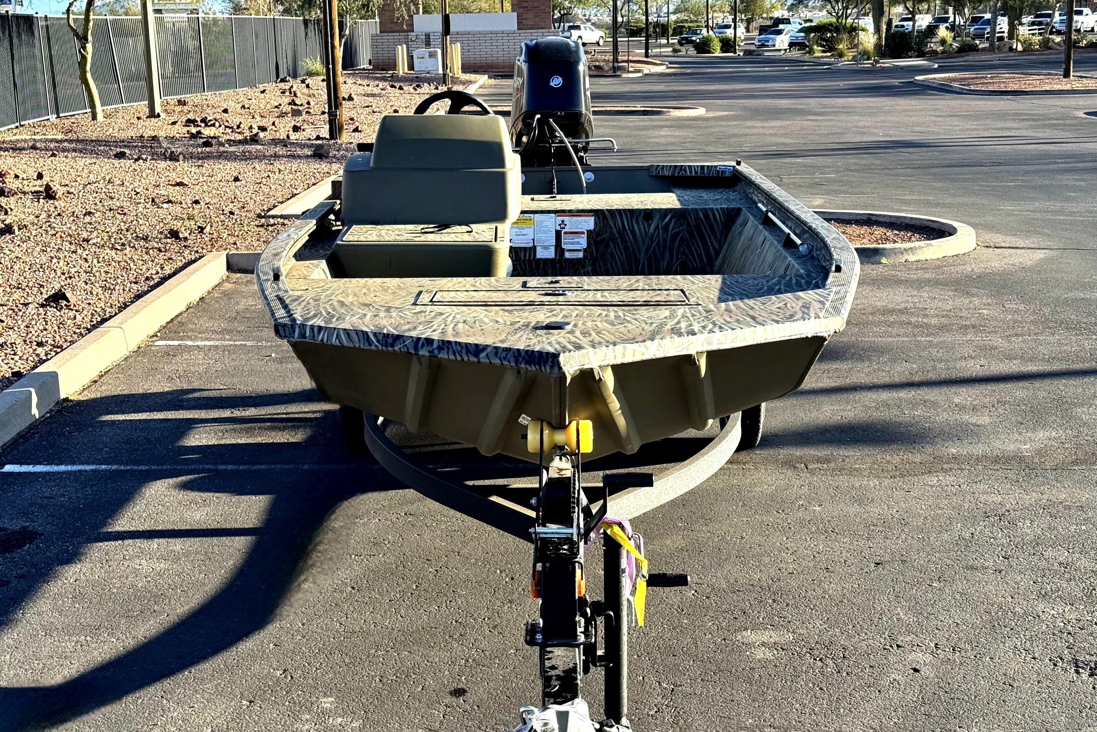 2026 Tracker Grizzly 1648 SC boat on trailer in parking lot.