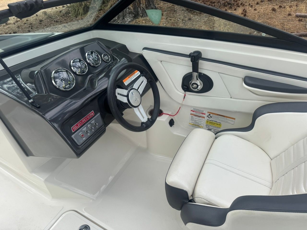 The image shows the cockpit of a 2016 Sea Ray SPX 190 Outboard with a sleek steering wheel and gauges.