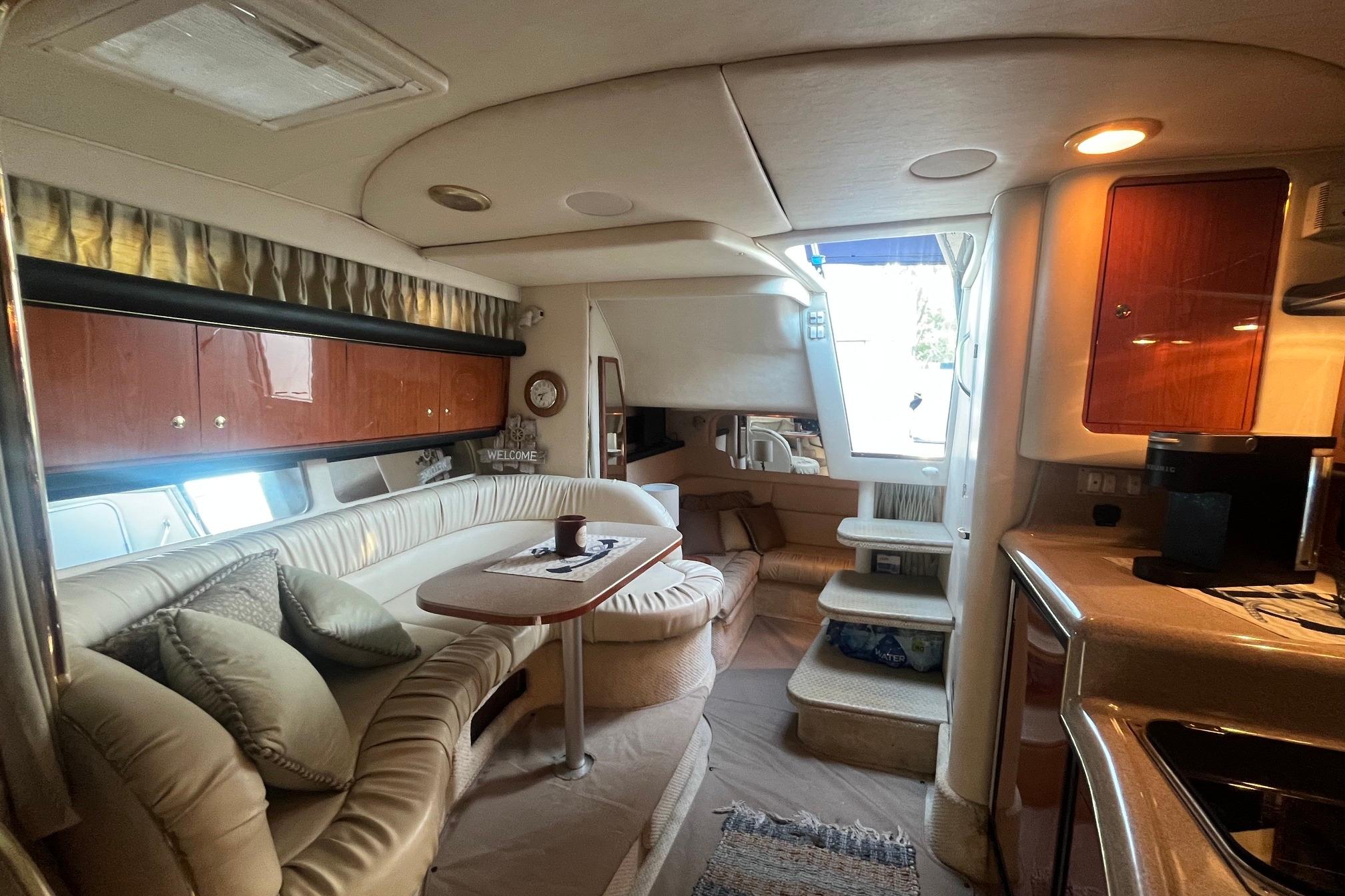 Luxurious interior of a 2001 Sea Ray 340 Sundancer yacht with elegant seating and cabinetry.