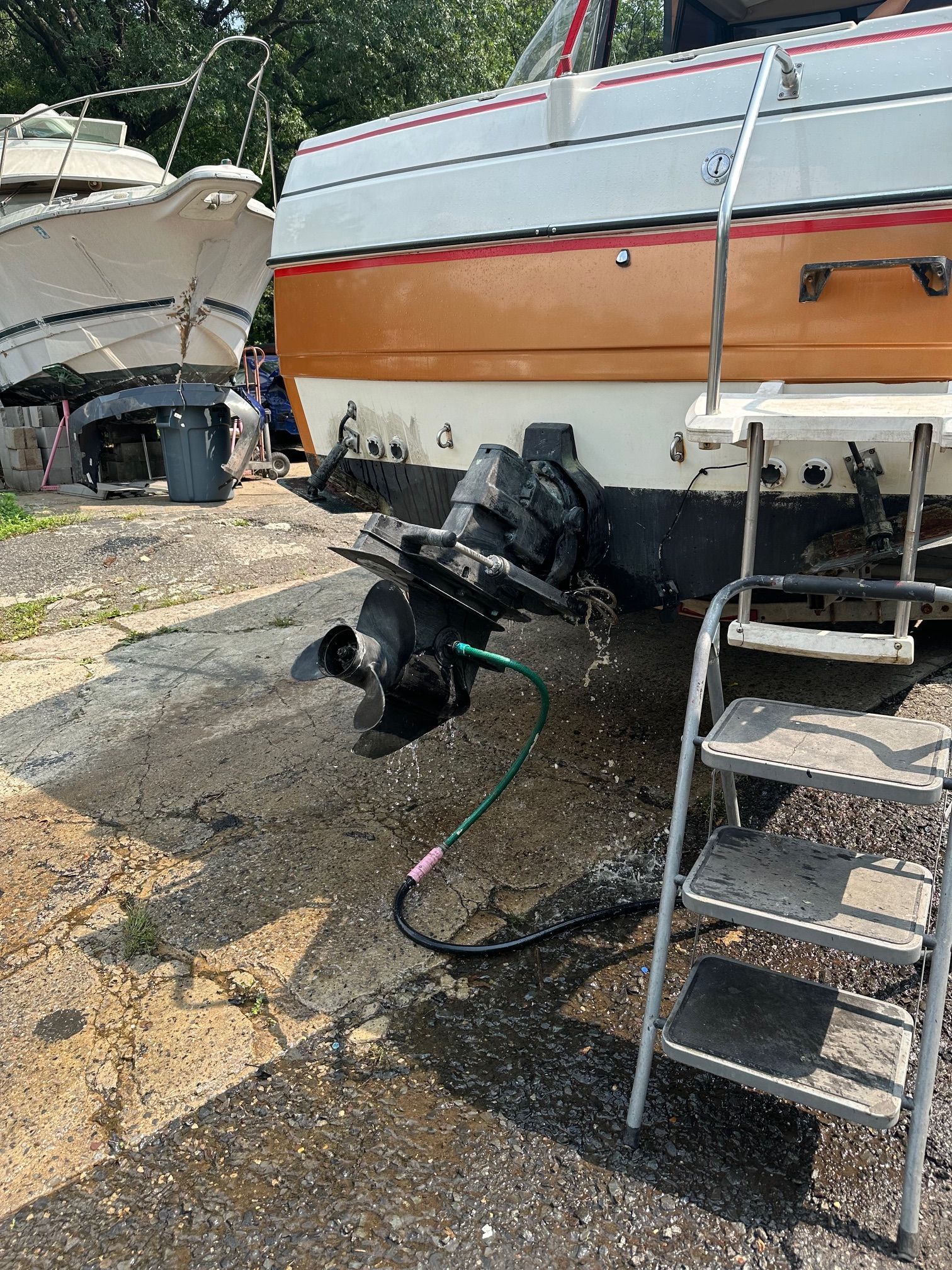 A 2006 Bayliner Sierra boat is on dry dock with a ladder beside it.