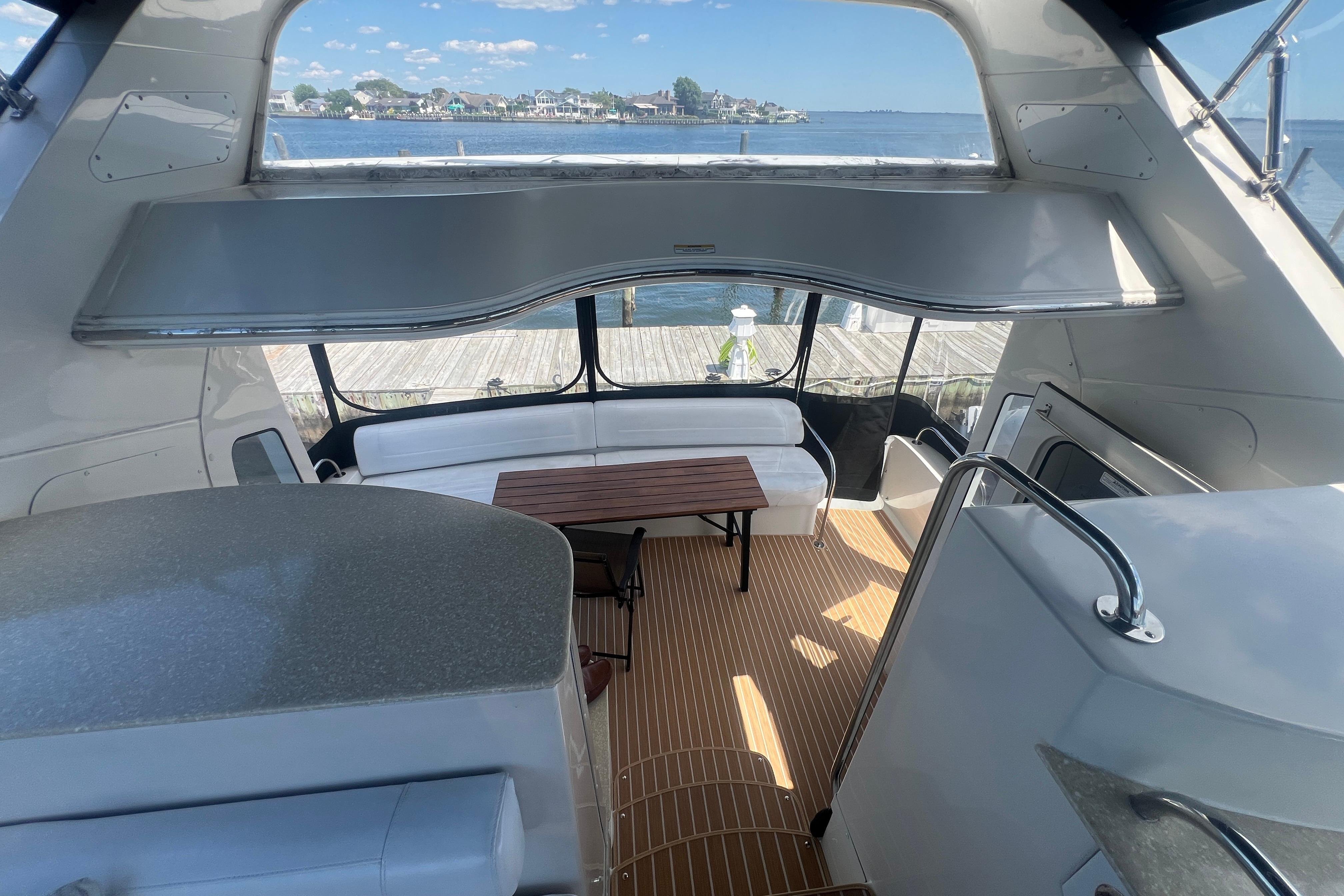 Interior view of 2006 Carver 43 Motor Yacht with seating and table, overlooking water.