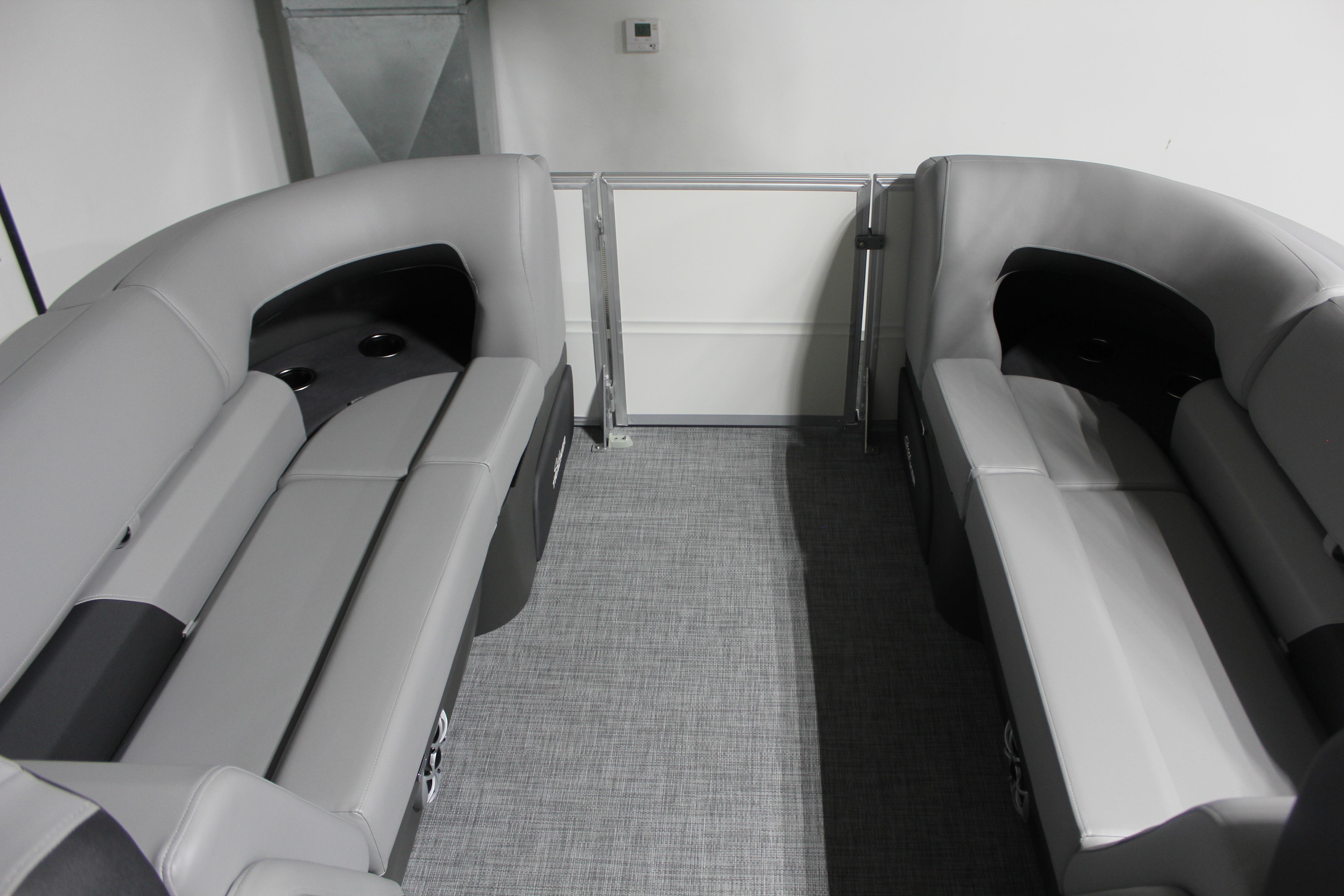 2026 Sun Tracker Party Barge 22 DLX interior with gray seating and cup holders.