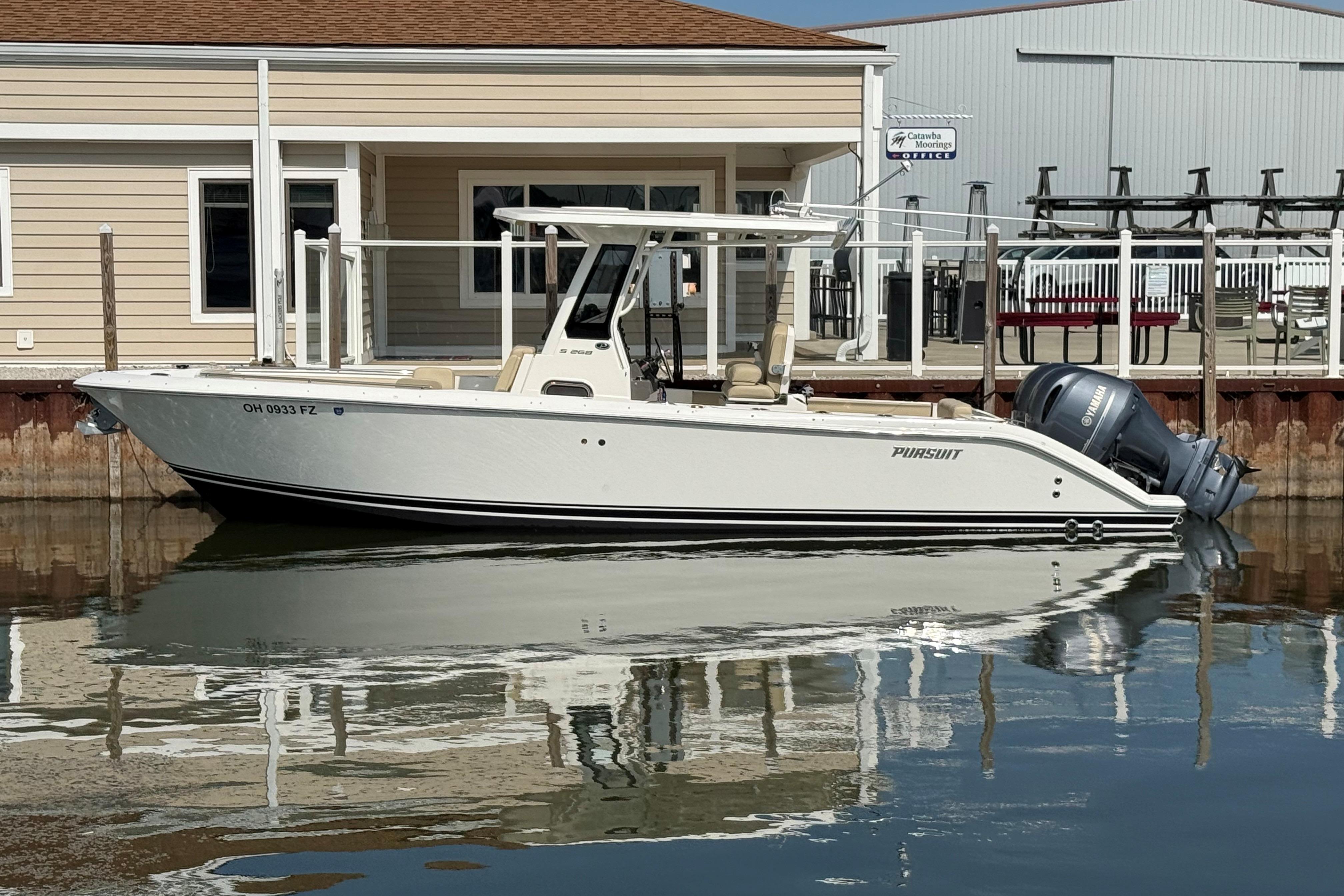 2021 Pursuit S 268 Sport boat docked at marina with twin Yamaha engines.
