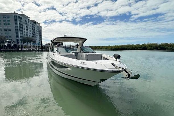2020 Sea Ray SLX 350 Outboard boat on calm water near modern buildings.
