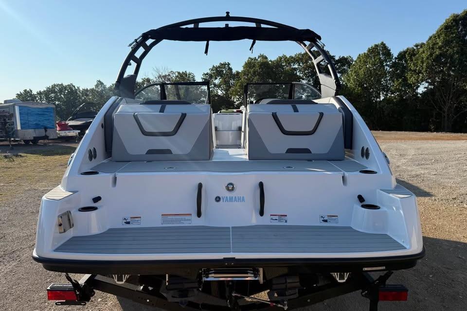 2026 Yamaha Boats AR220, rear view, on land with trees in background.