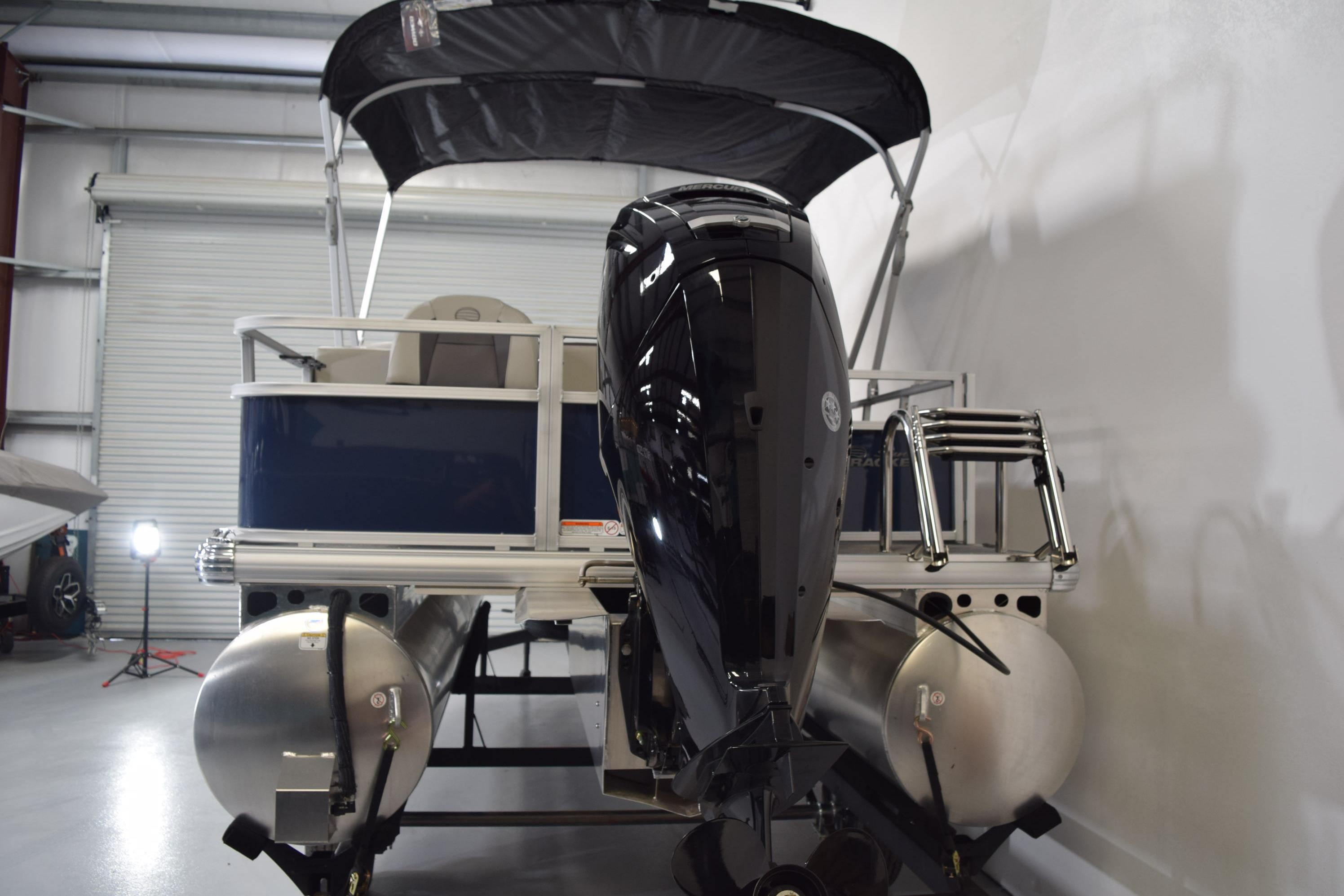 2026 Sun Tracker Bass Buggy 18 DLX pontoon boat in a showroom.