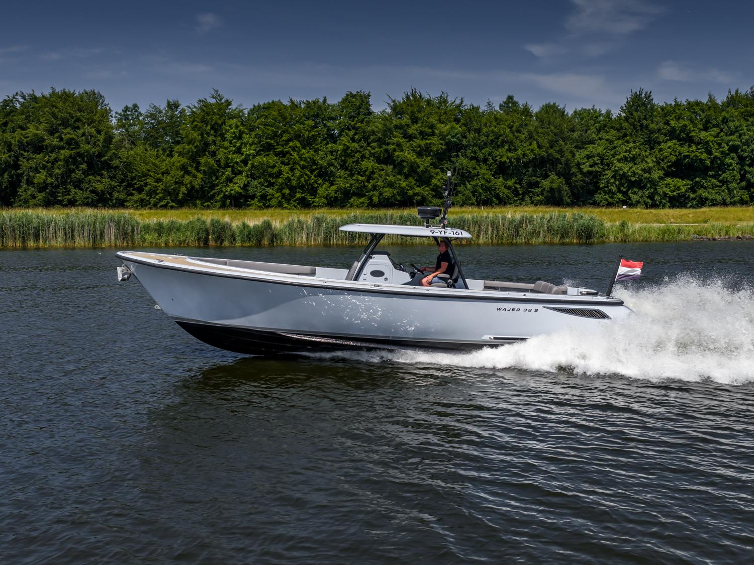 2017 Wajer 38 S motorboat cruising on a scenic river with lush greenery.