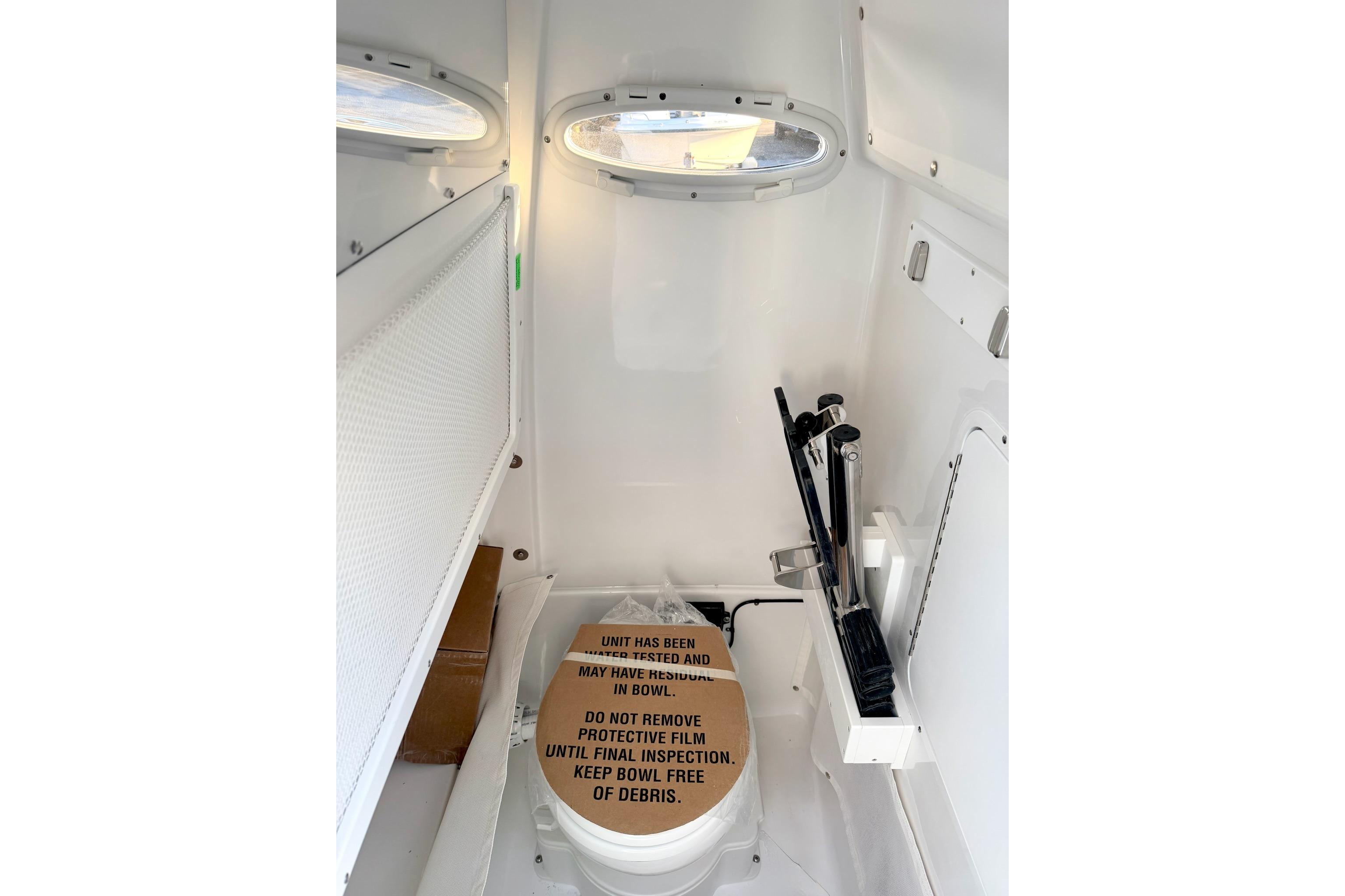 Interior of 2026 Sea Hunt Ultra 275 Coffin Box boat with toilet and storage.