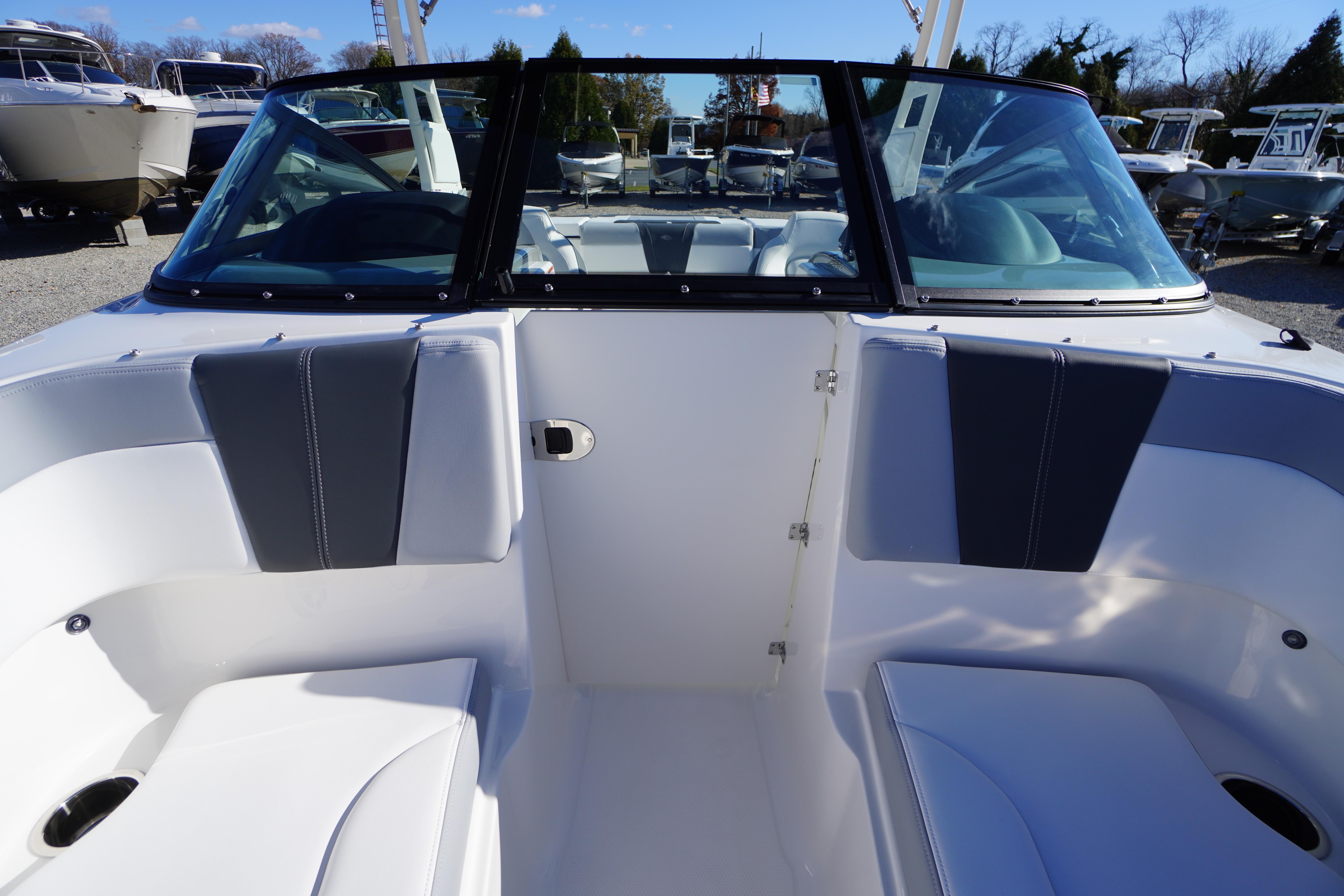2026 Chaparral 23 SSi boat interior with seating and windshield, displayed outdoors.