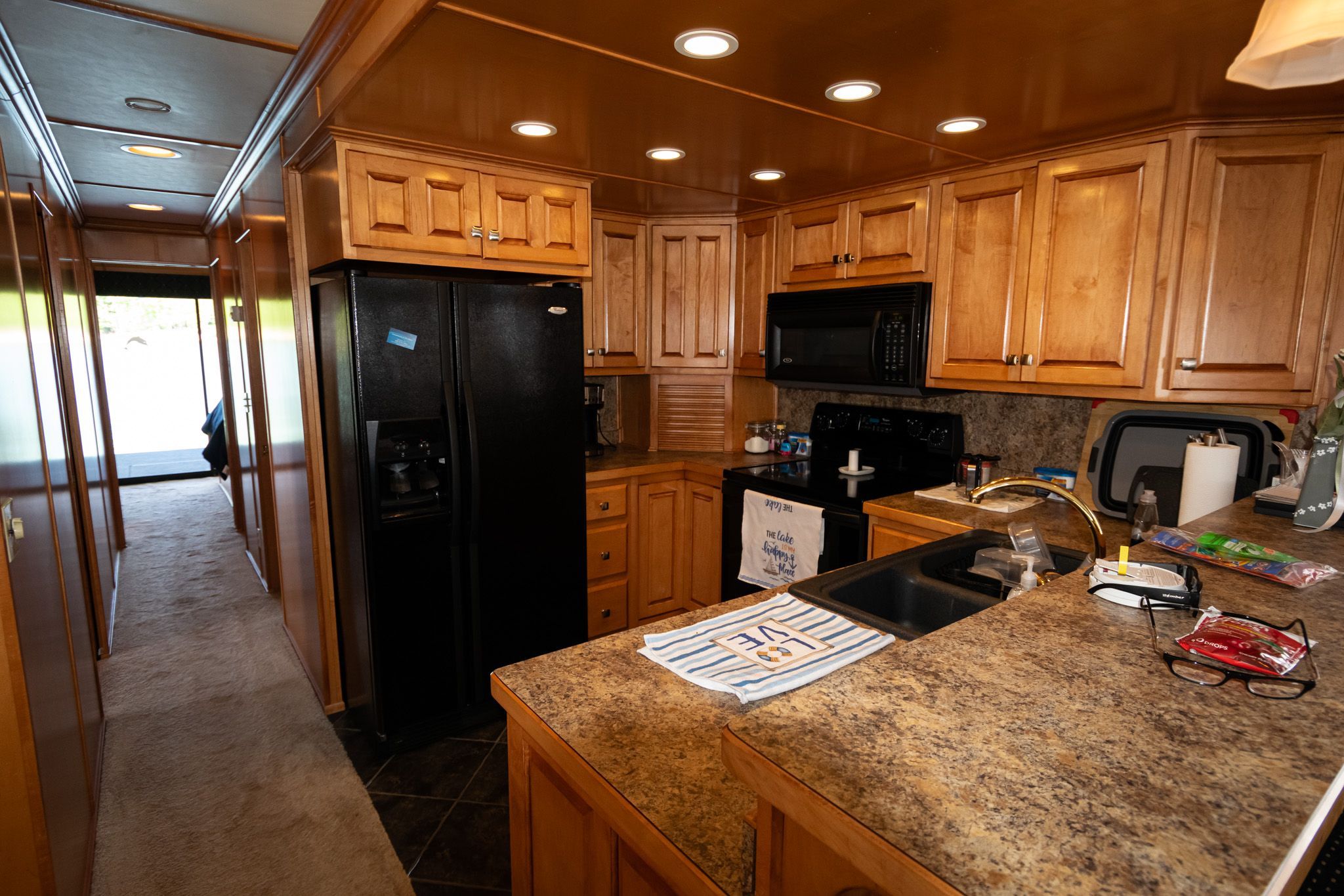 Kitchen in a 2003 Lakeview 16x70 houseboat with wooden cabinets.