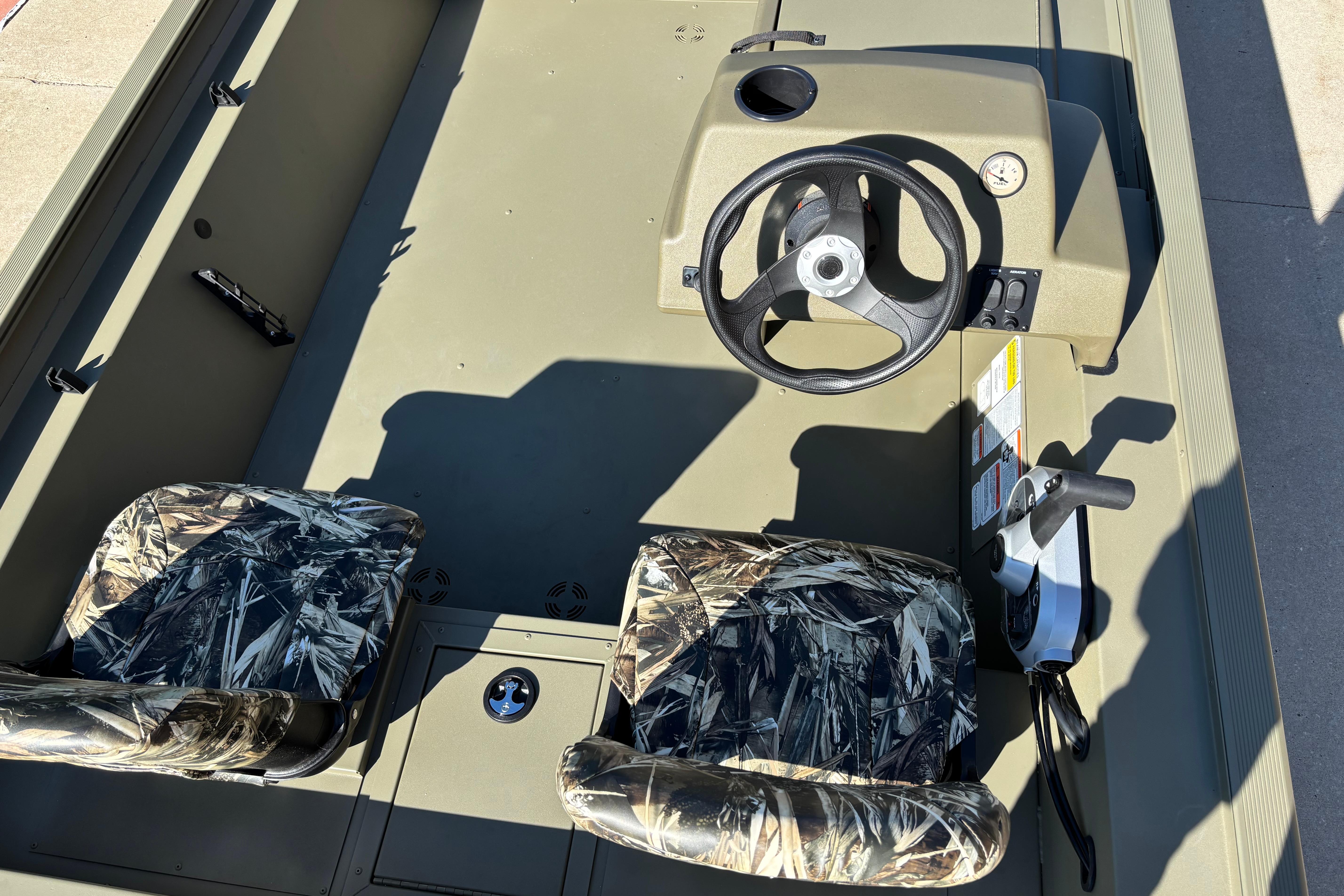 2026 Tracker Grizzly 1754 SC boat interior with camo seats and steering console.