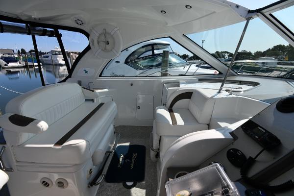 2010 Cruisers Yachts 390 Sports Coupe interior with white seating and helm, docked at marina.