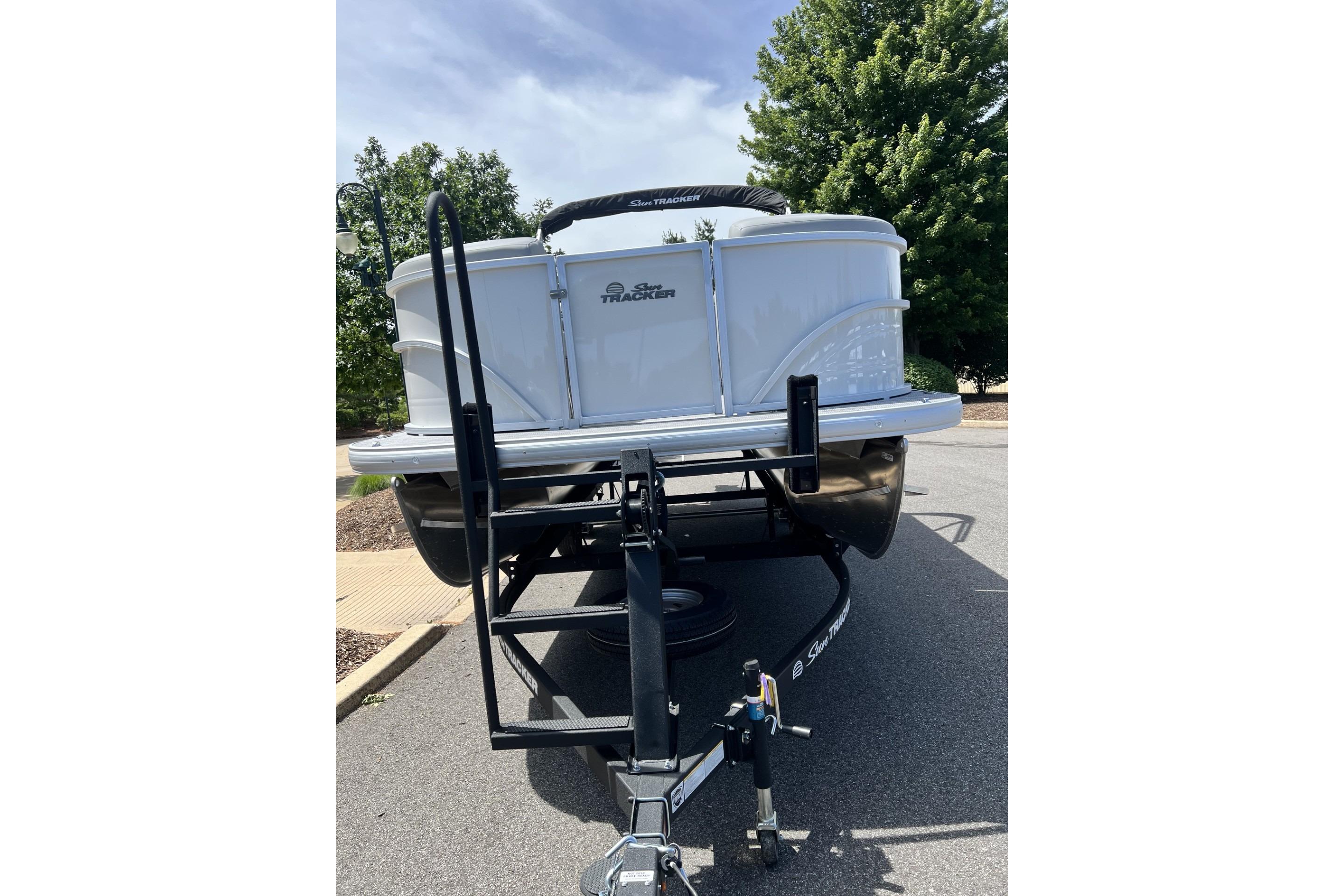 2026 Sun Tracker Party Barge 20 DLX pontoon boat on trailer, parked outdoors.