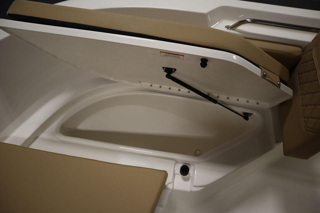 Open storage compartment on 2026 Bayliner Trophy T20CC boat with cushioned seating.