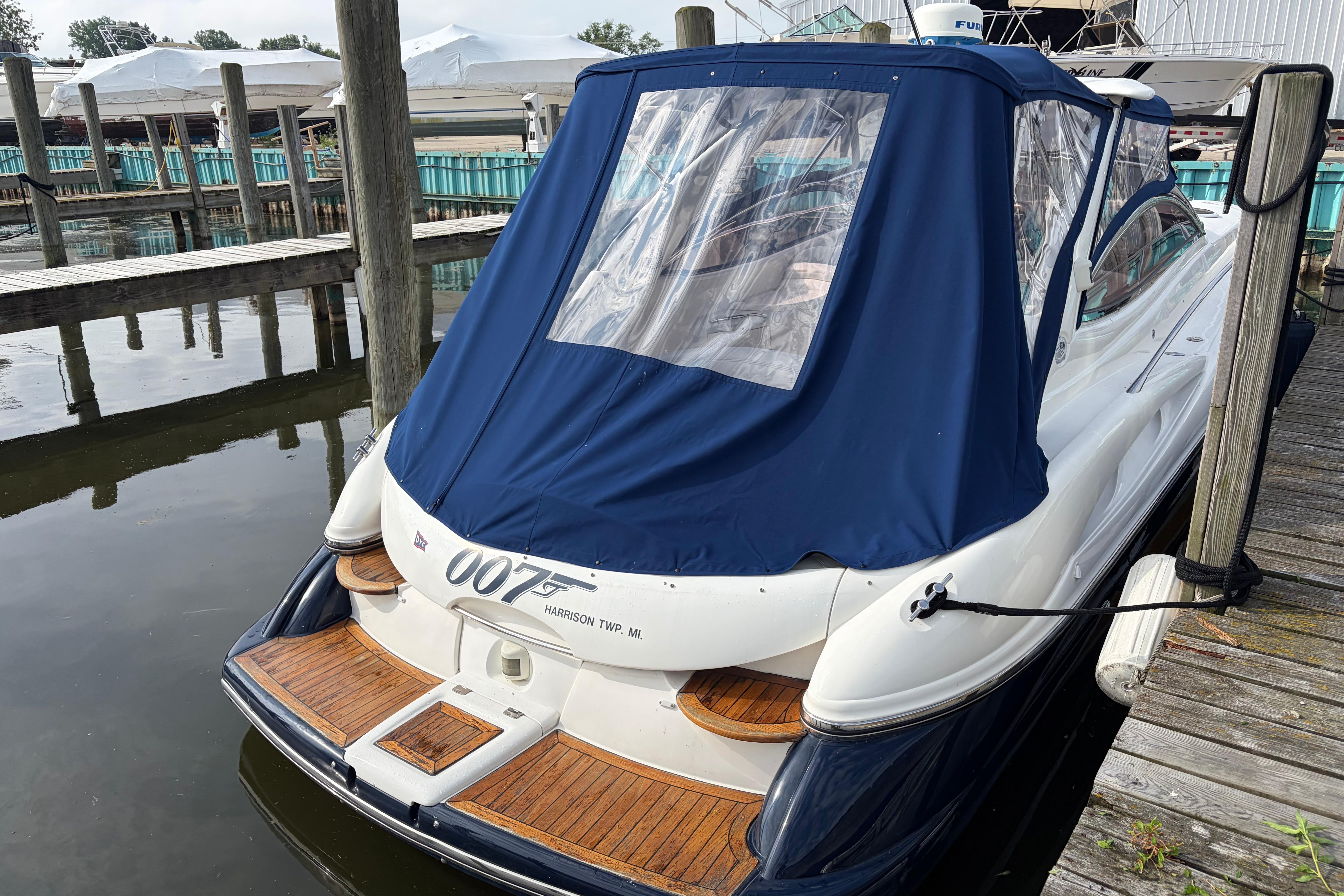 Sunseeker Superhawk 34 yacht, 2000 model, docked with blue cover in marina.