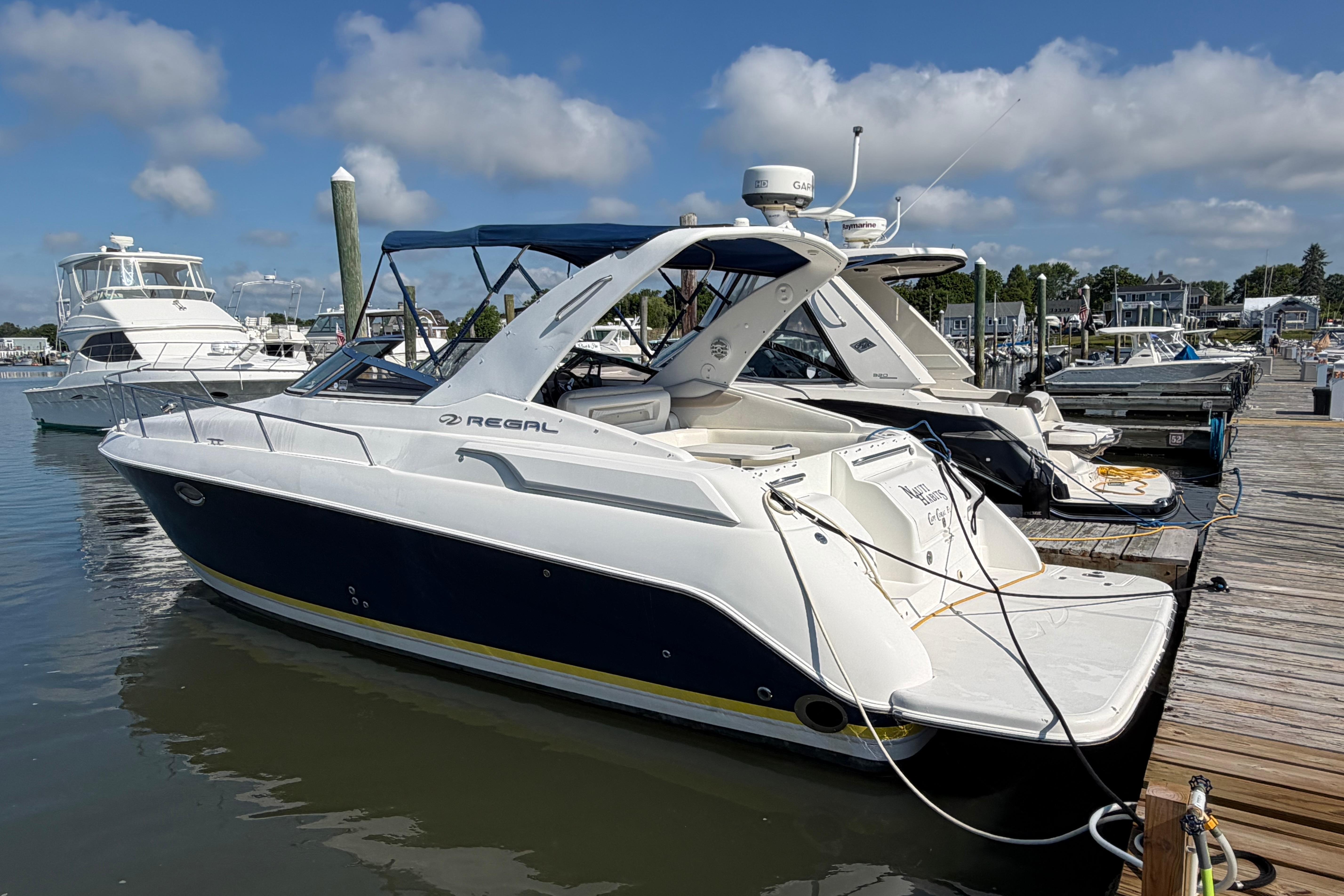 2003 Regal Commodore 3260 yacht docked at marina under blue sky.