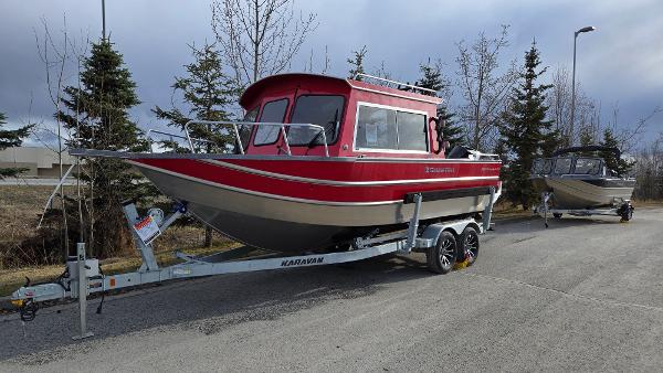 2024 Spartan 220 Maximus boat on trailer, parked on road with trees in background.
