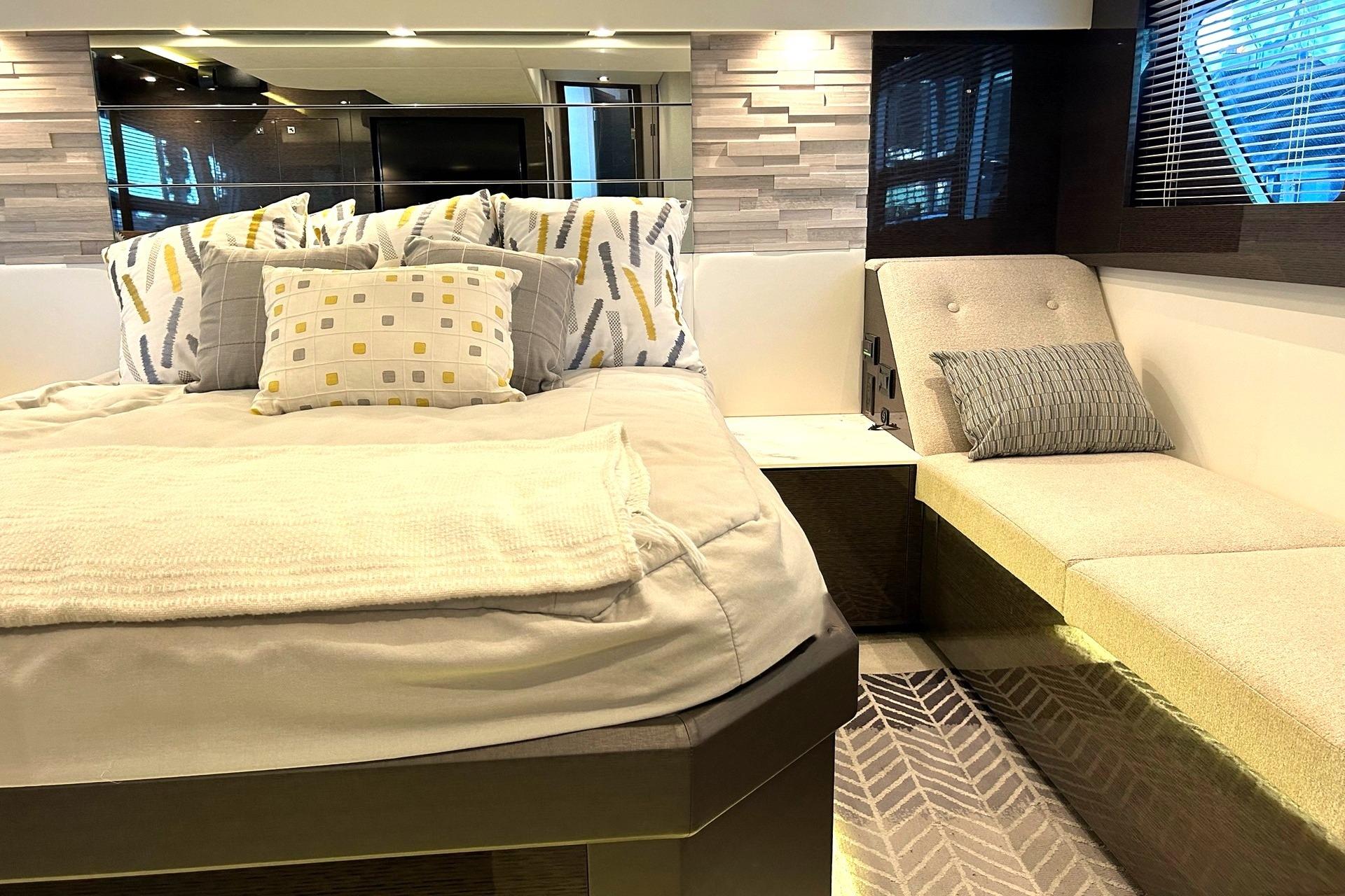 Luxurious 2021 Cruisers Yachts 50 Cantius bedroom with modern decor and cozy seating area.