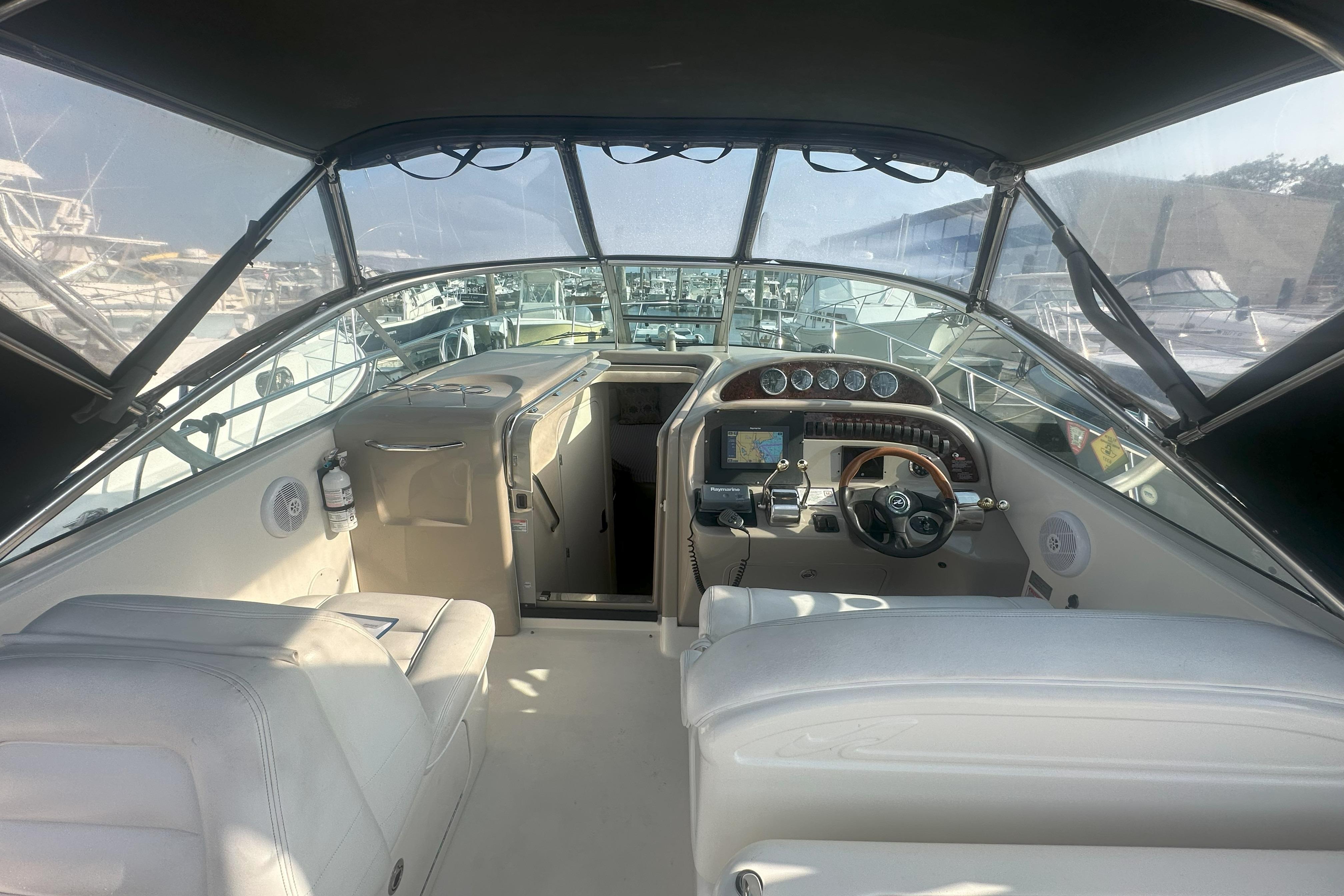 Interior view of 2006 Sea Ray 290 Amberjack boat cockpit with steering wheel and controls.