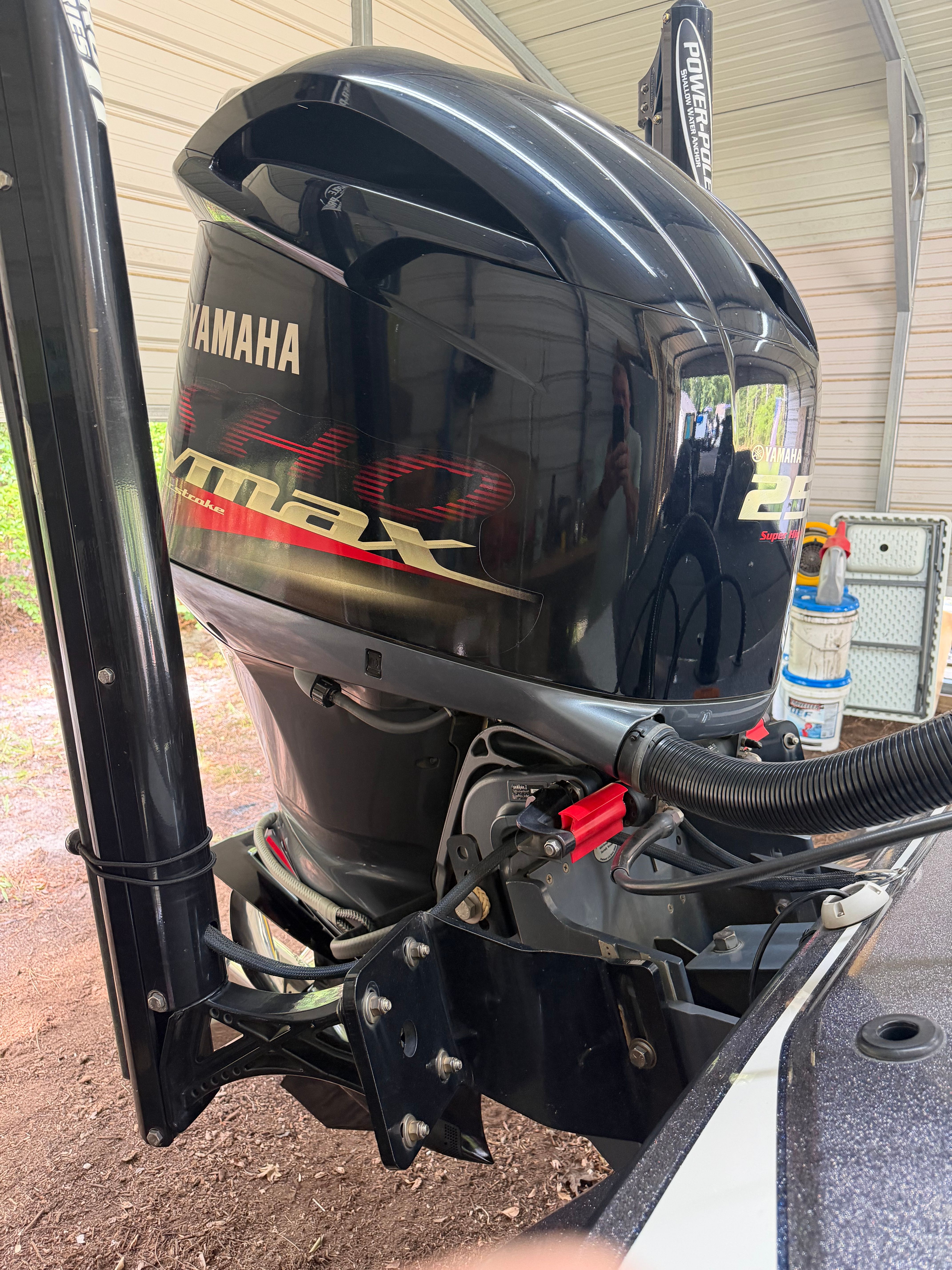 A Yamaha outboard motor is attached to a boat, situated in a covered area.