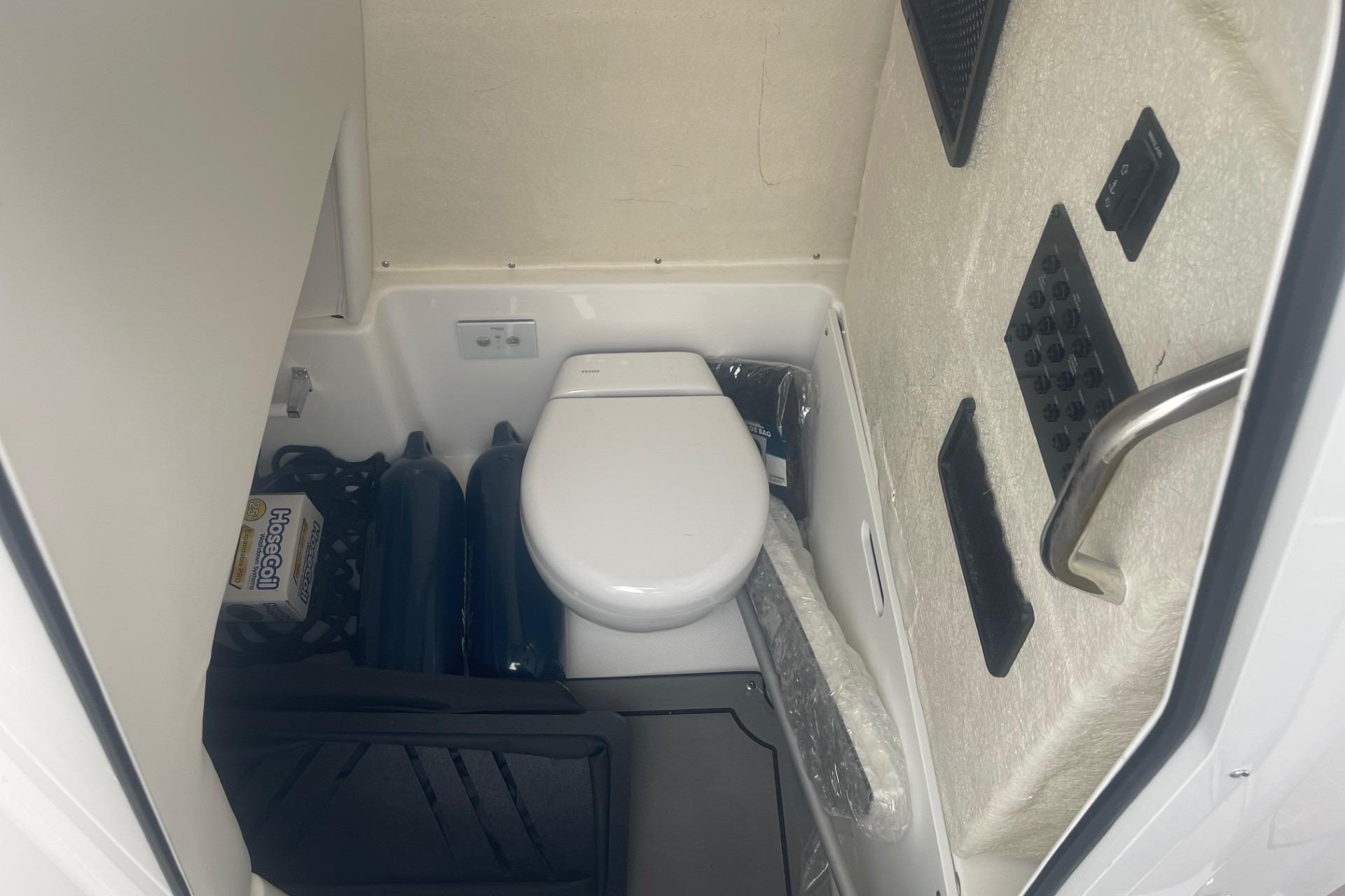 Interior of 2025 Hurricane Center Console 24 OB boat with compact marine toilet.