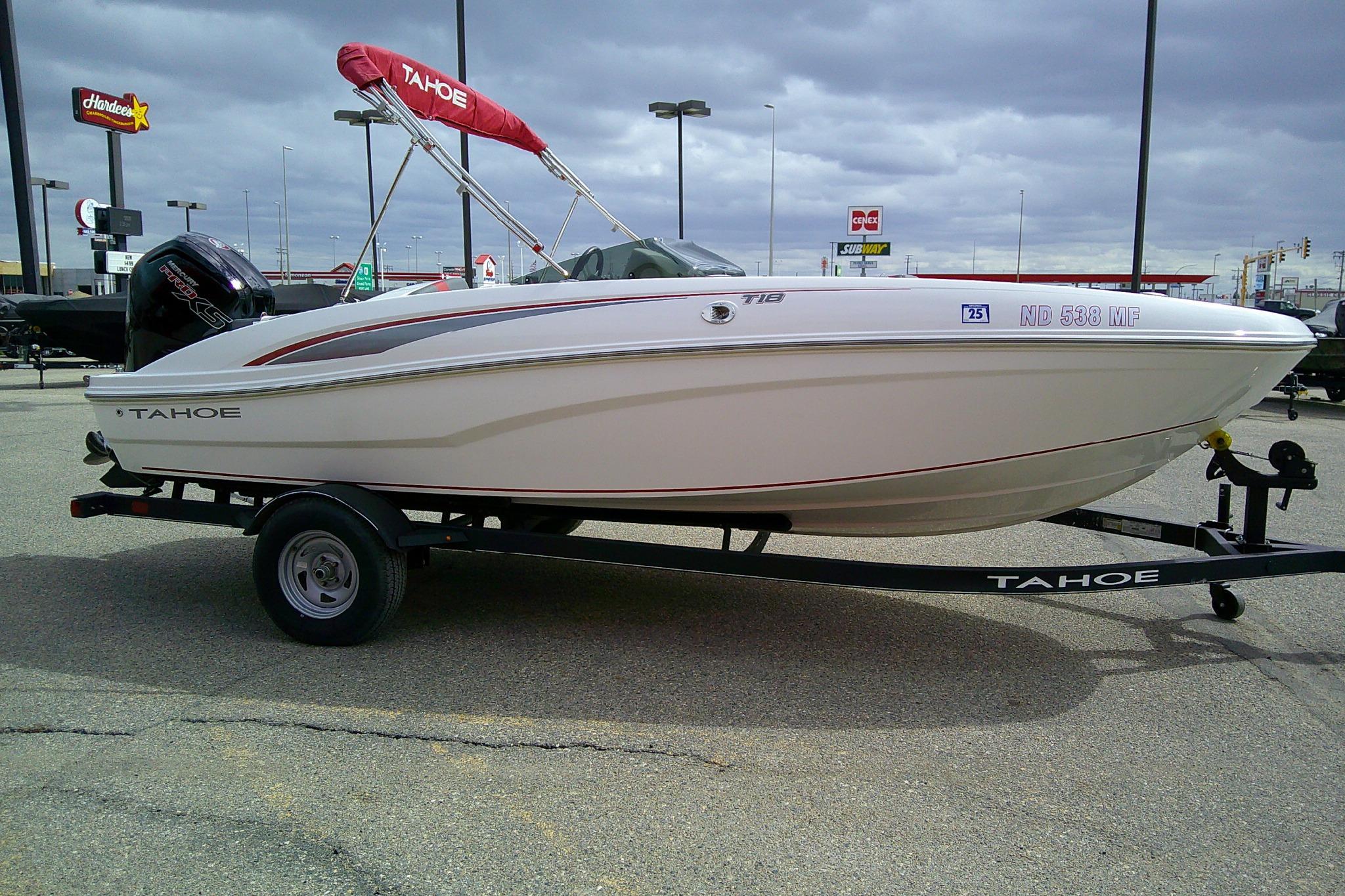 2024 Tahoe T18 boat on trailer in parking lot, overcast sky.