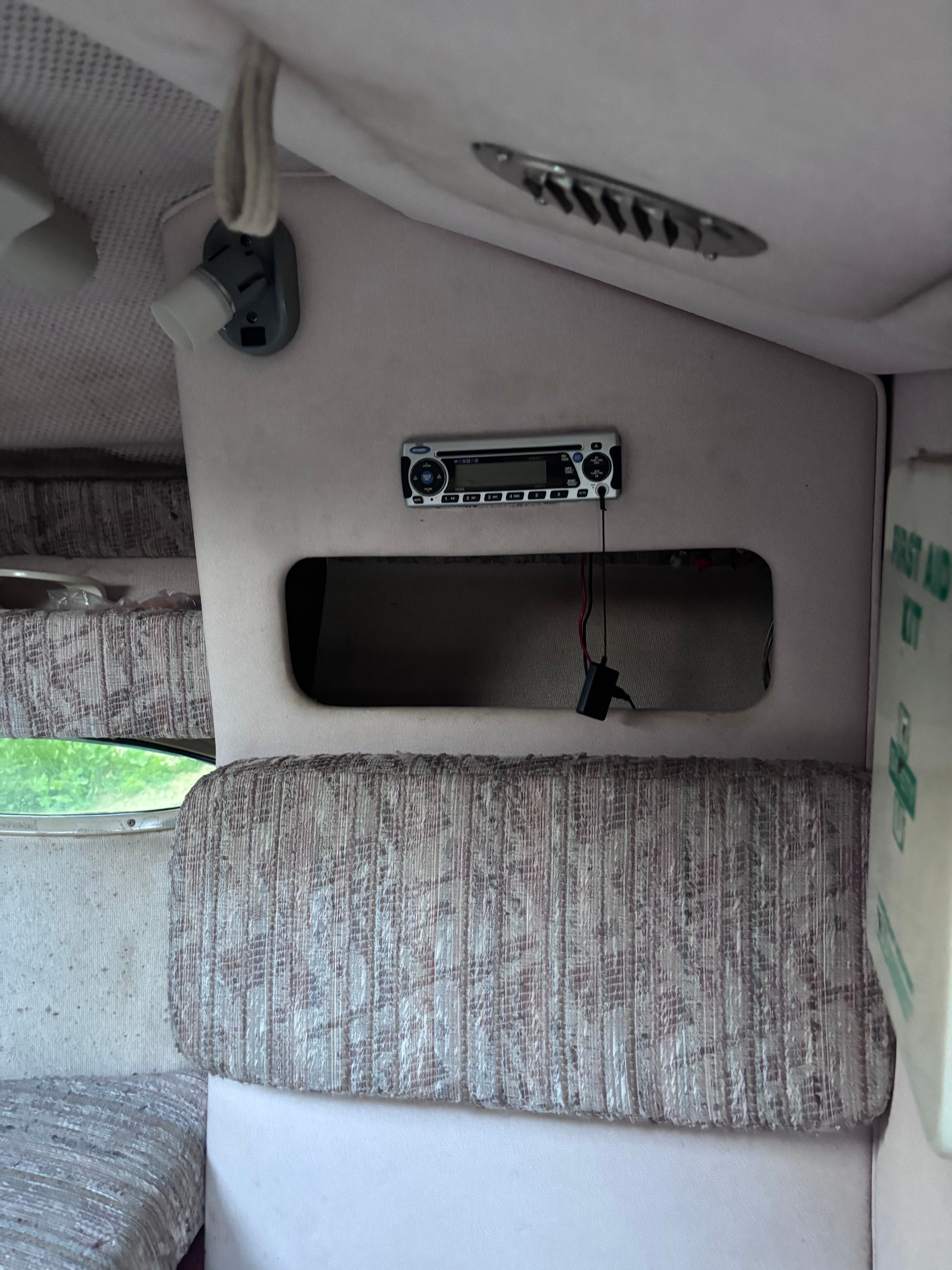 Interior of a 1989 Sea Ray Sundancer with upholstered seating and a radio.