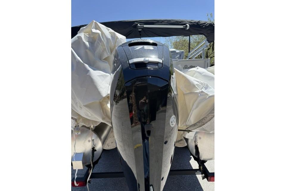 2026 Sun Tracker Party Barge 18 DLX with Mercury 75 engine, covered and parked.