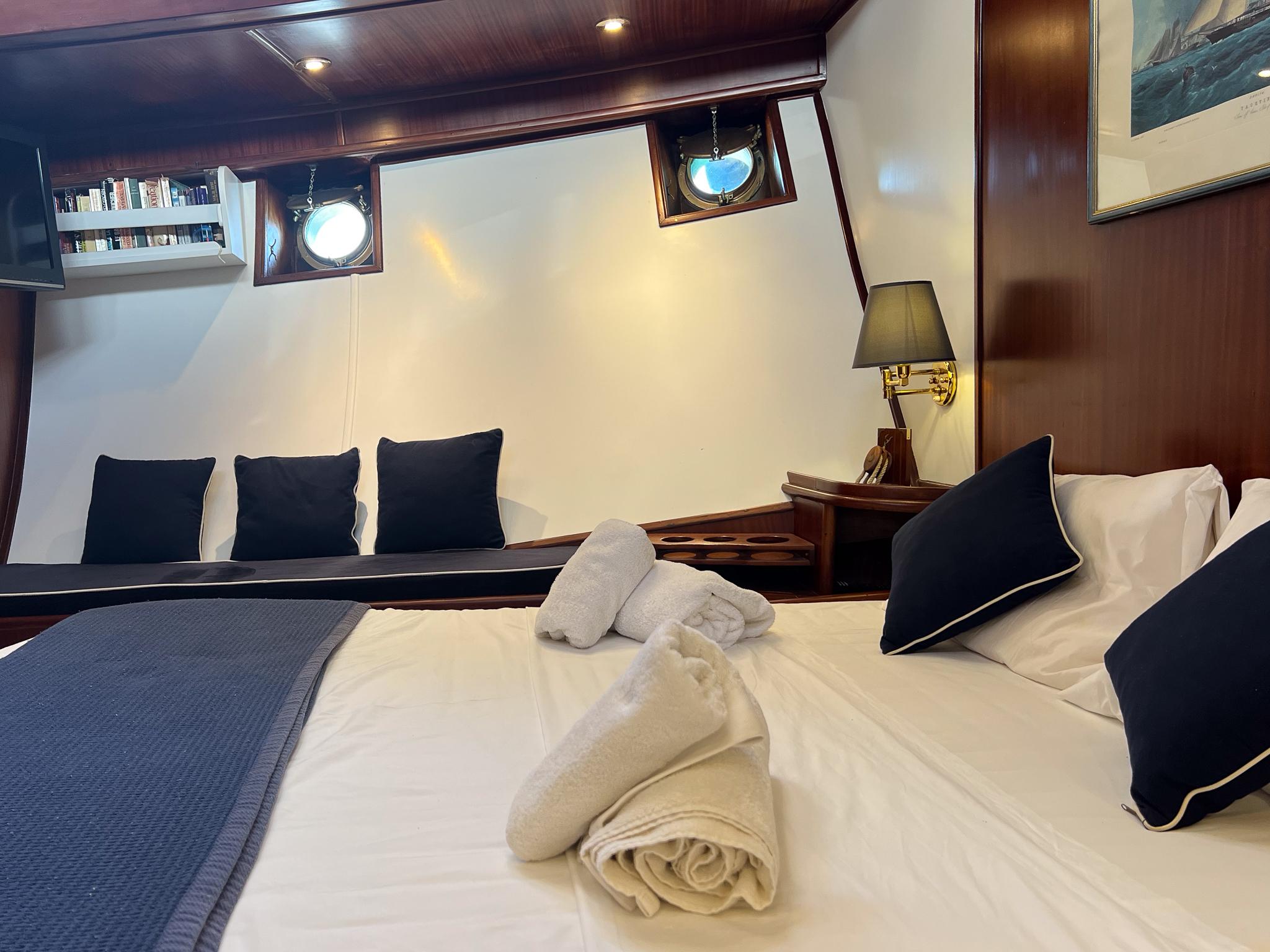 Luxurious cabin interior of a 1969 Psarros Shipyard yacht with elegant bedding and decor.