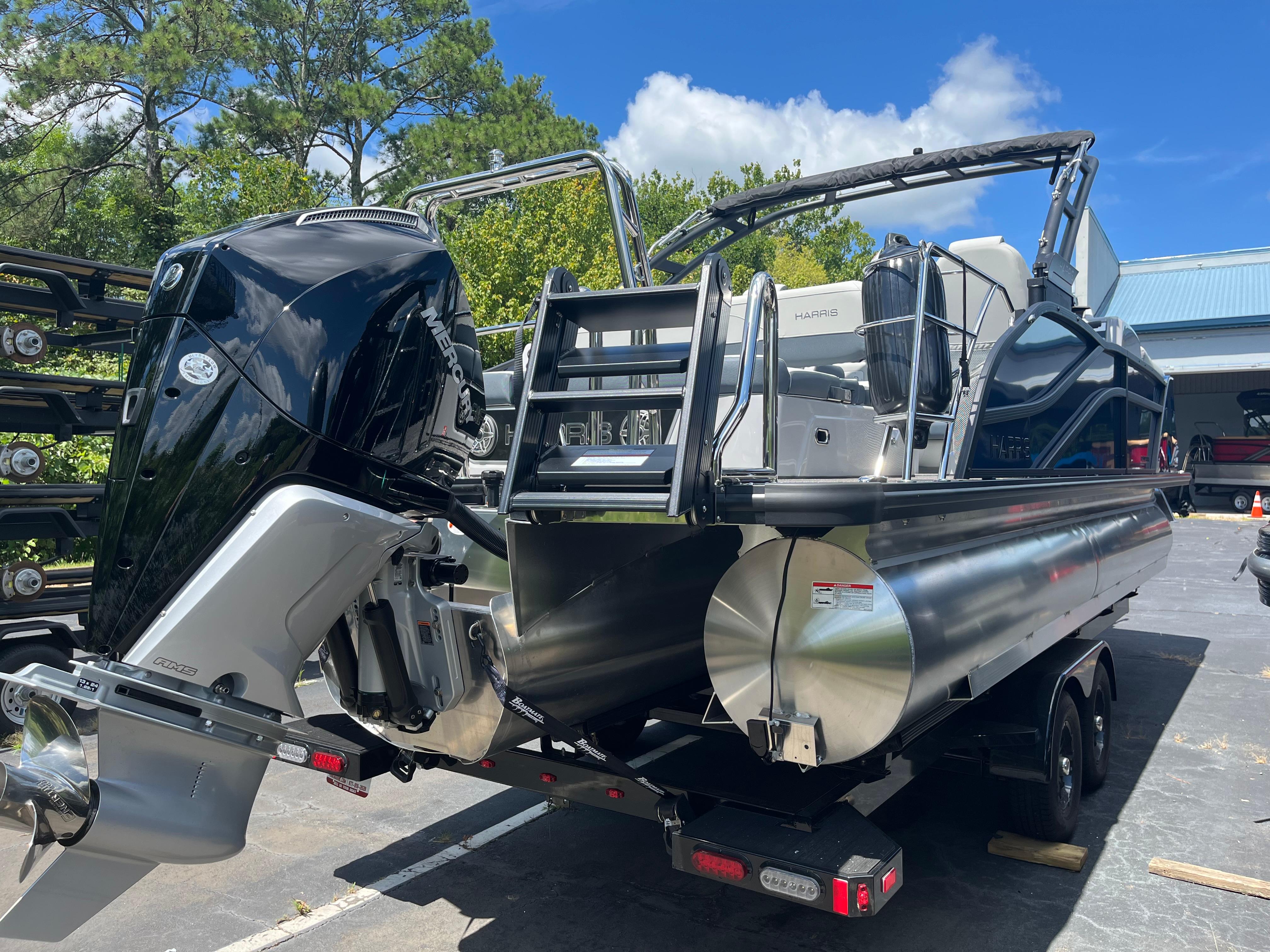 2026 Harris Grand Mariner 230 pontoon boat with powerful outboard motor on trailer.