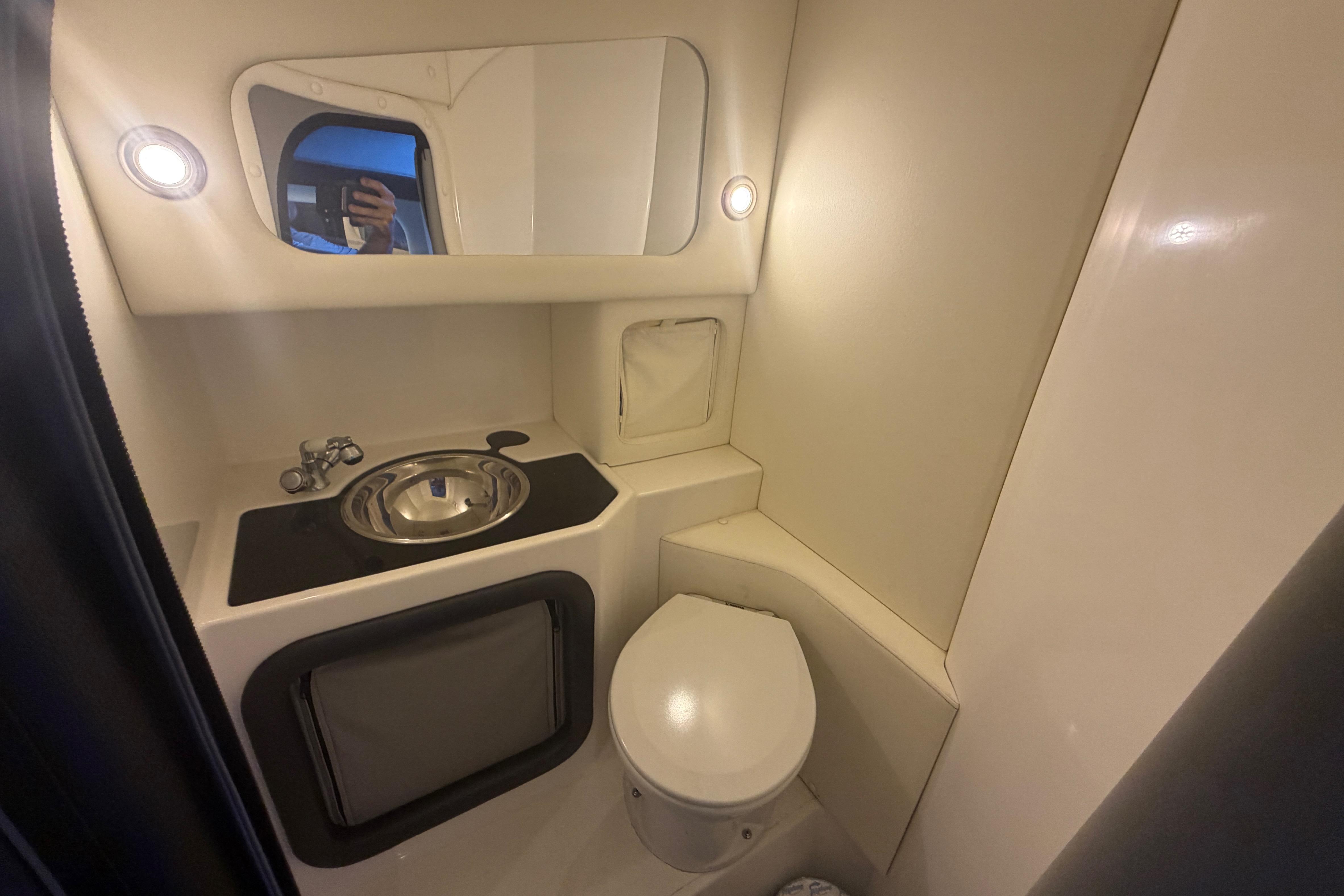 Compact bathroom in 2013 Nor-Tech 477 SPX Vee Bottom boat, featuring sink and toilet.