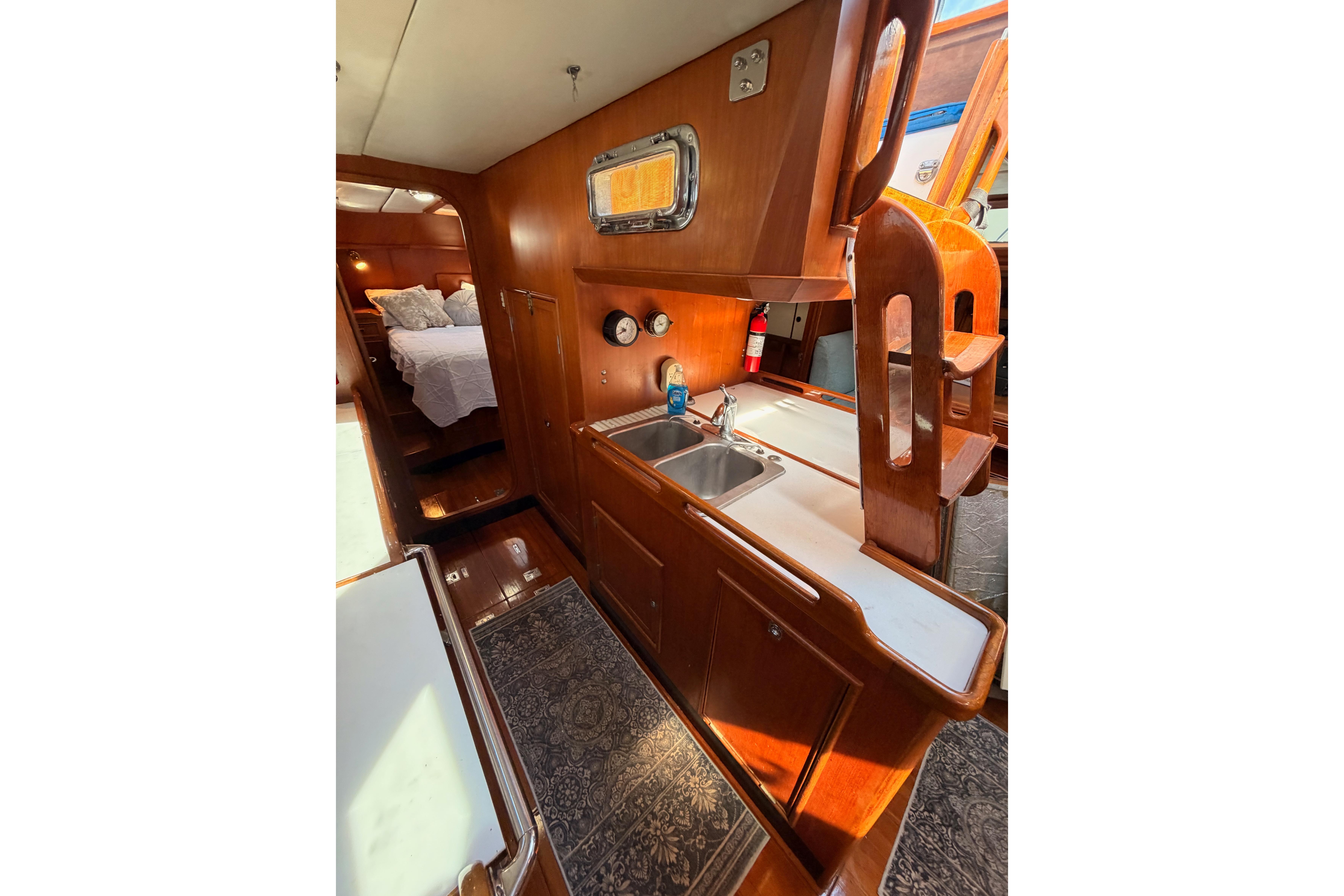 Interior of 1991 Hylas 51 yacht featuring a cozy kitchen and sleeping area.