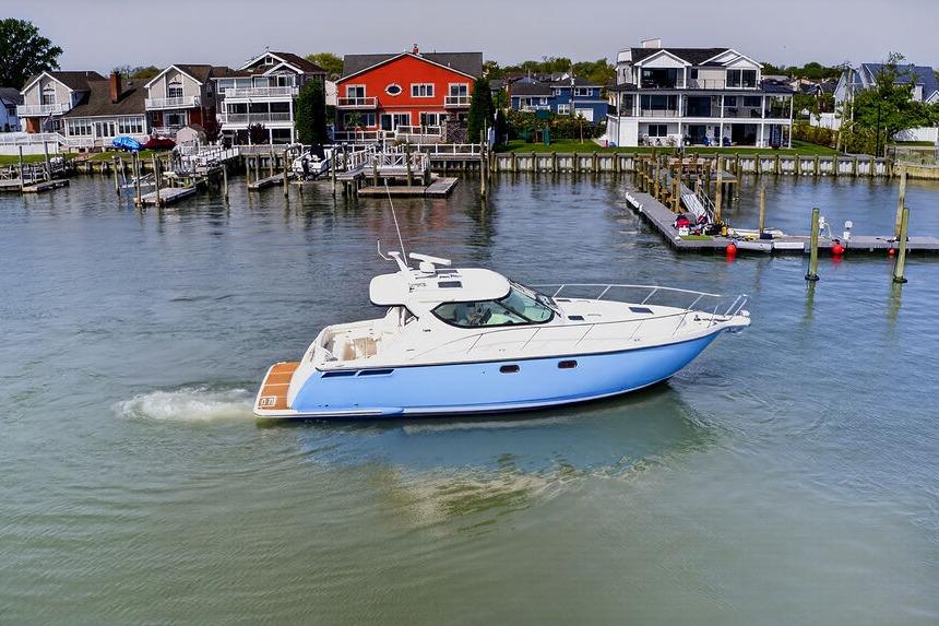 2006 Tiara Yachts 4300 Sovran cruising near waterfront homes and docks.