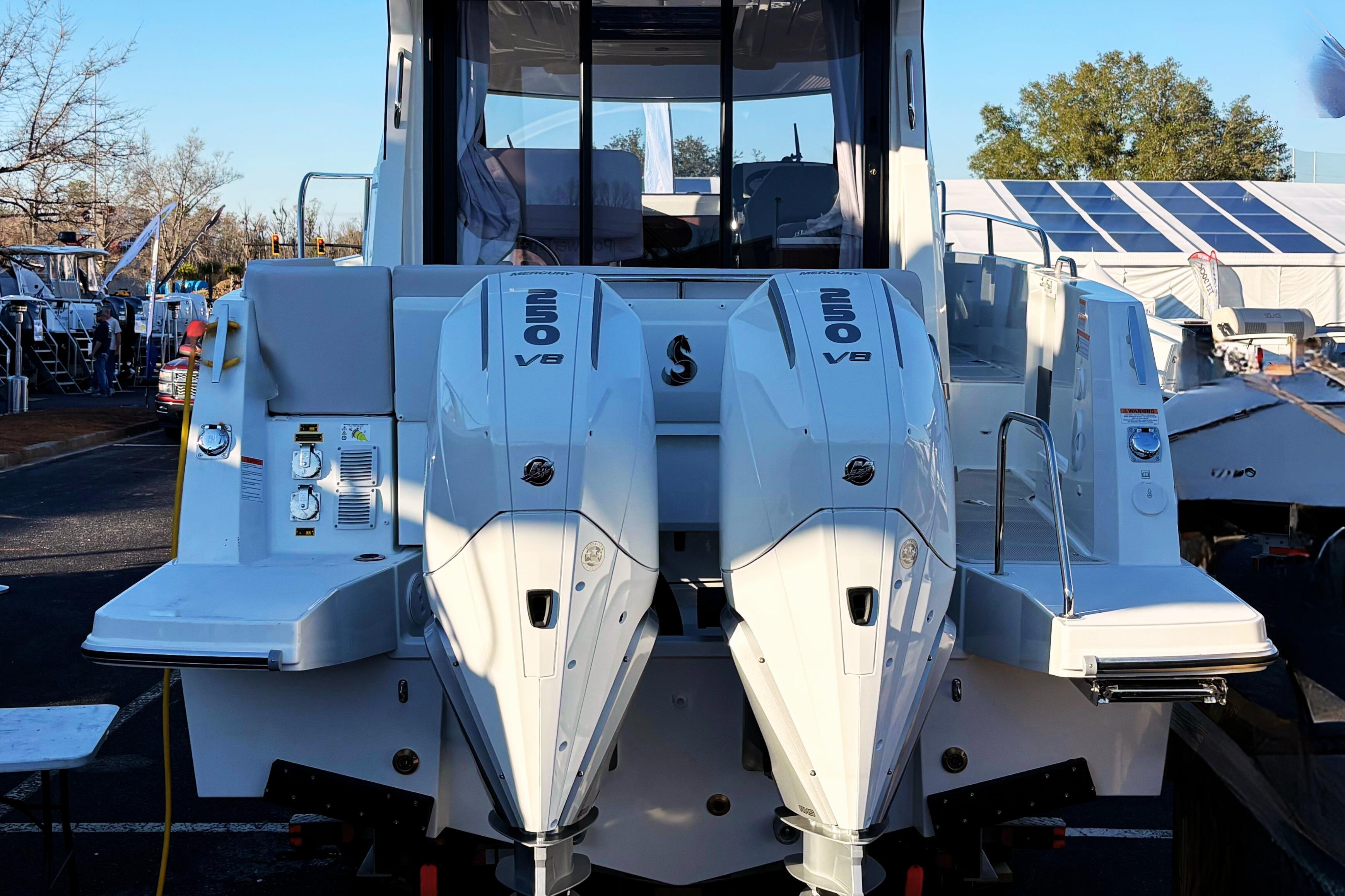 2026 Beneteau Antares 9 with twin 250 V8 engines, rear view at a boat show.