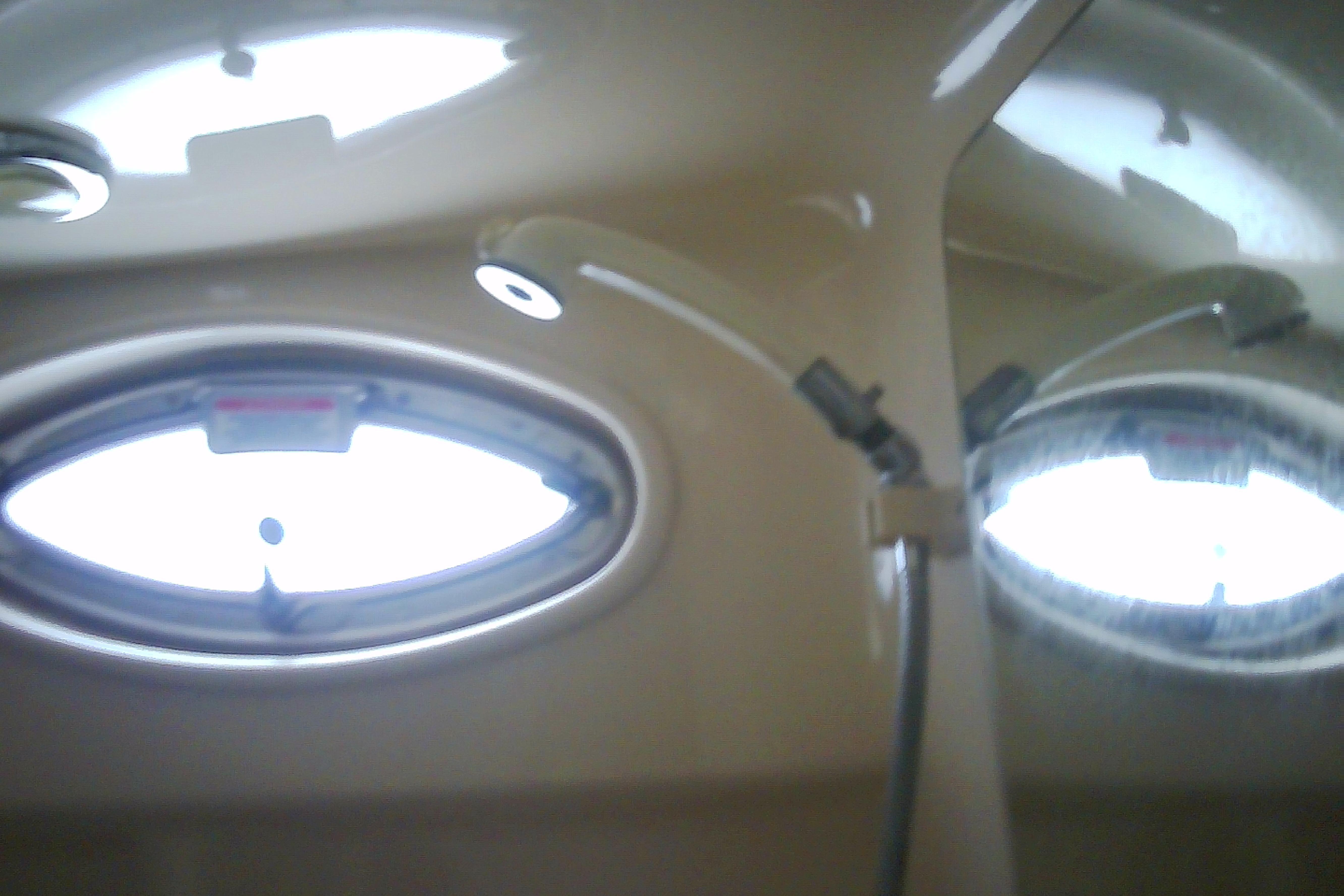 Interior of 2005 Sea Ray 300 Sundancer boat with oval windows and lighting.