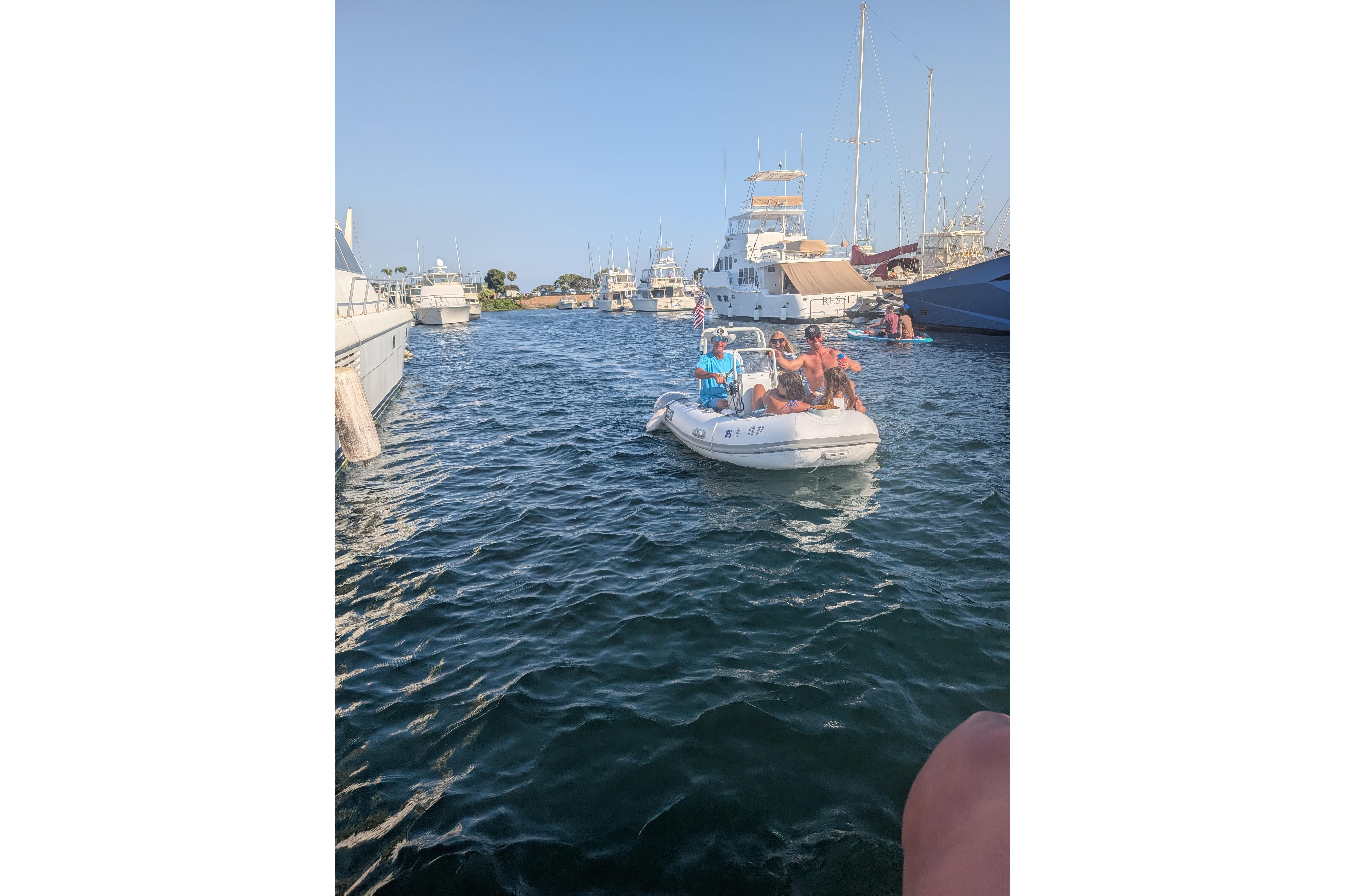 People enjoying a ride on a 2027 Tide Craft San Juan 11 boat in a marina.