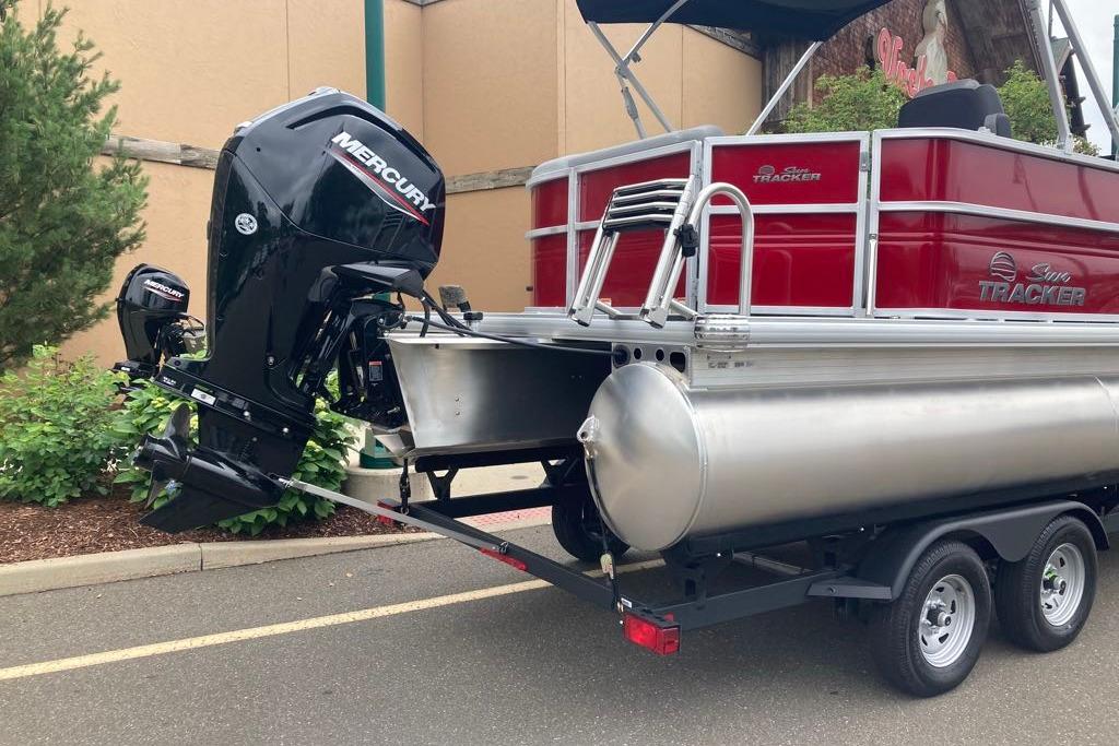 2026 Sun Tracker Party Barge 20 DLX pontoon boat on trailer with Mercury outboard motor.