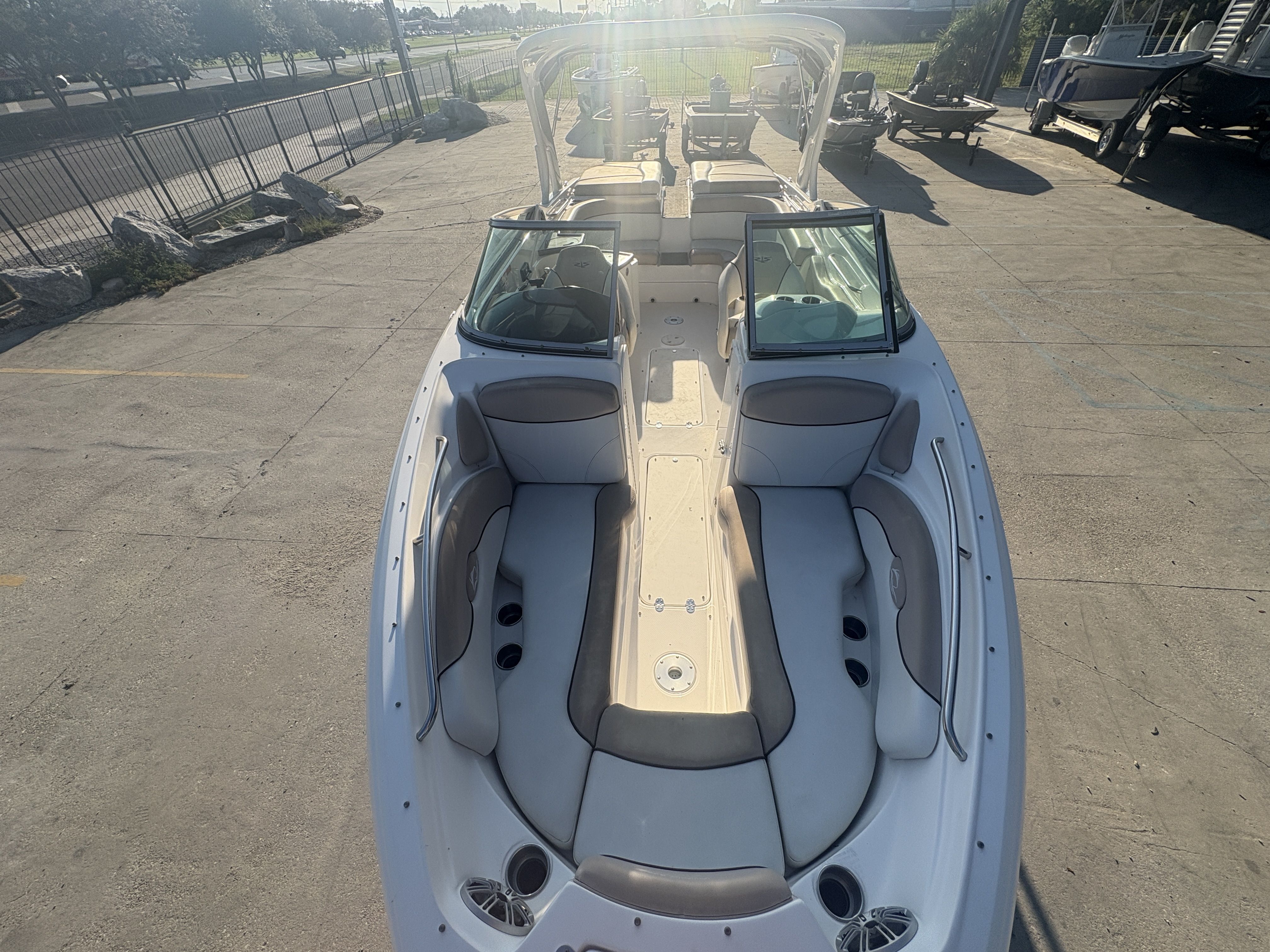 2013 Rinker Captiva 276 boat with spacious seating, parked outdoors in sunlight.